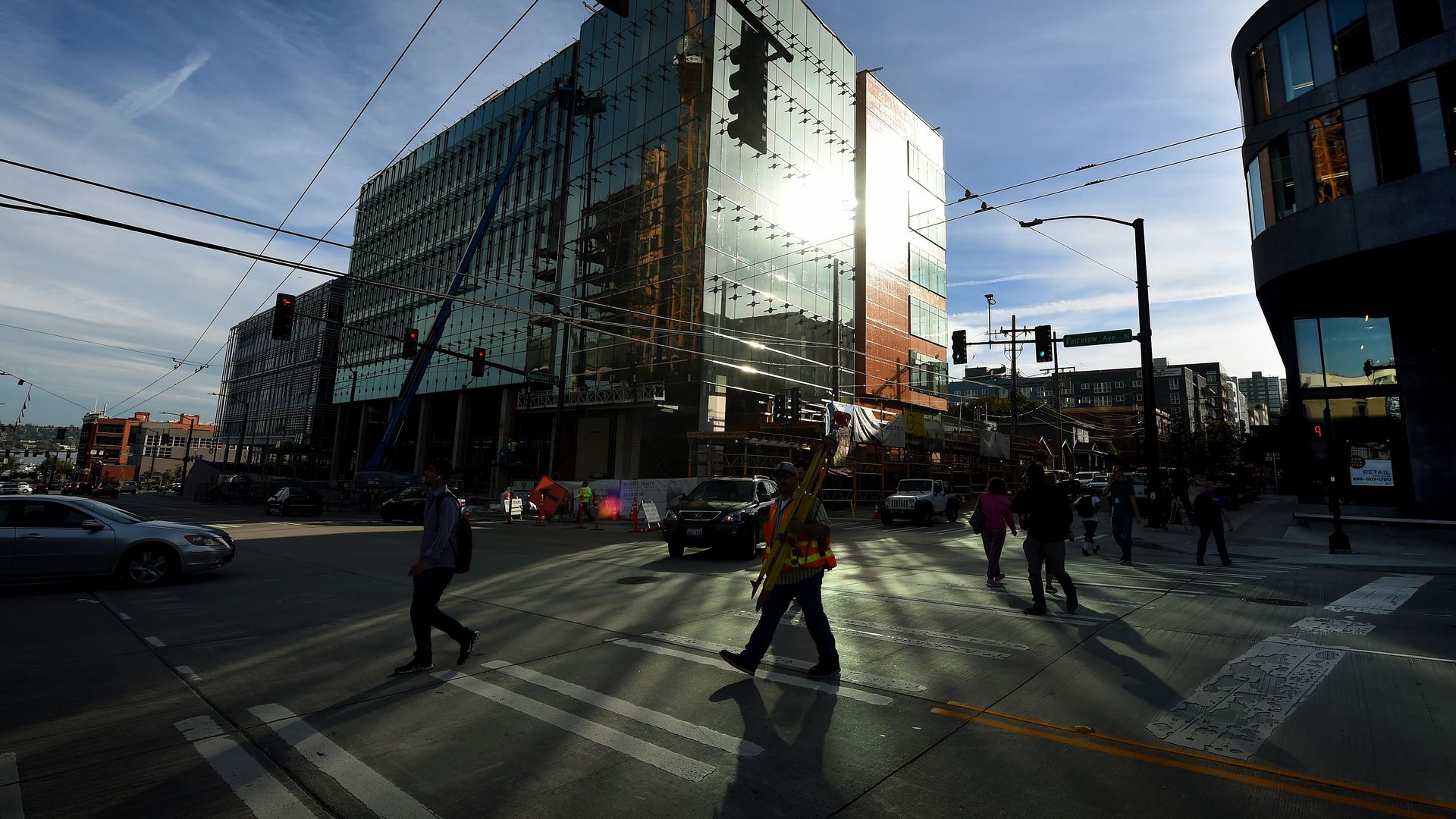 People walk past part of the new Amazon headquarter complex under construction in downtown Seatte