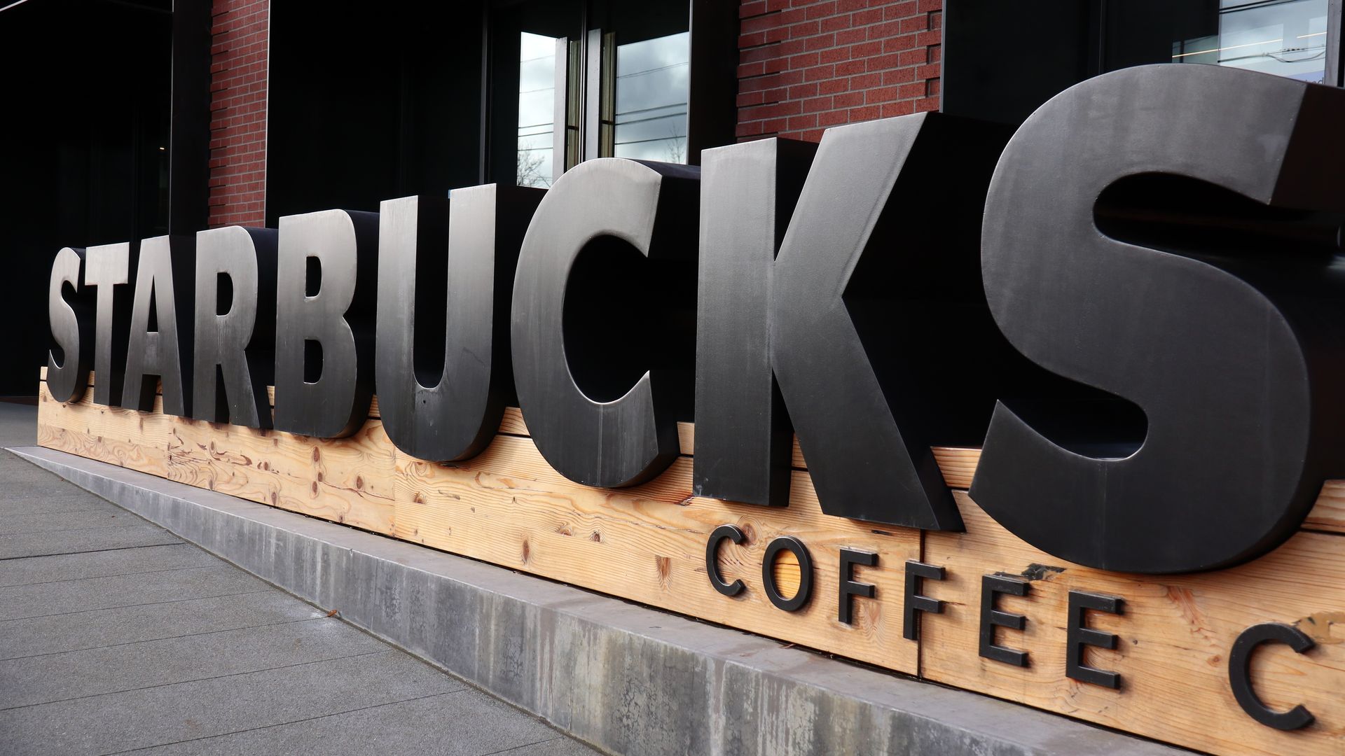 Photo of a giant black Starbucks sign mounted in front of an office building