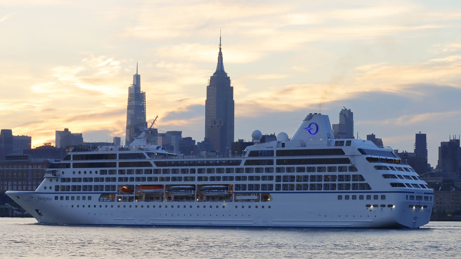 The Insignia cruise ship owned by Oceania Cruises sails in the Hudson River past the skyline of Manhattan in New York City as it returns to port at sunrise on July 19.