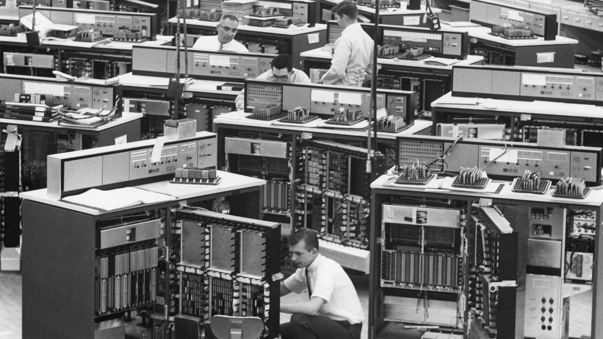 Black and white photo of giant IBM mainframe computers being inspected before shipping