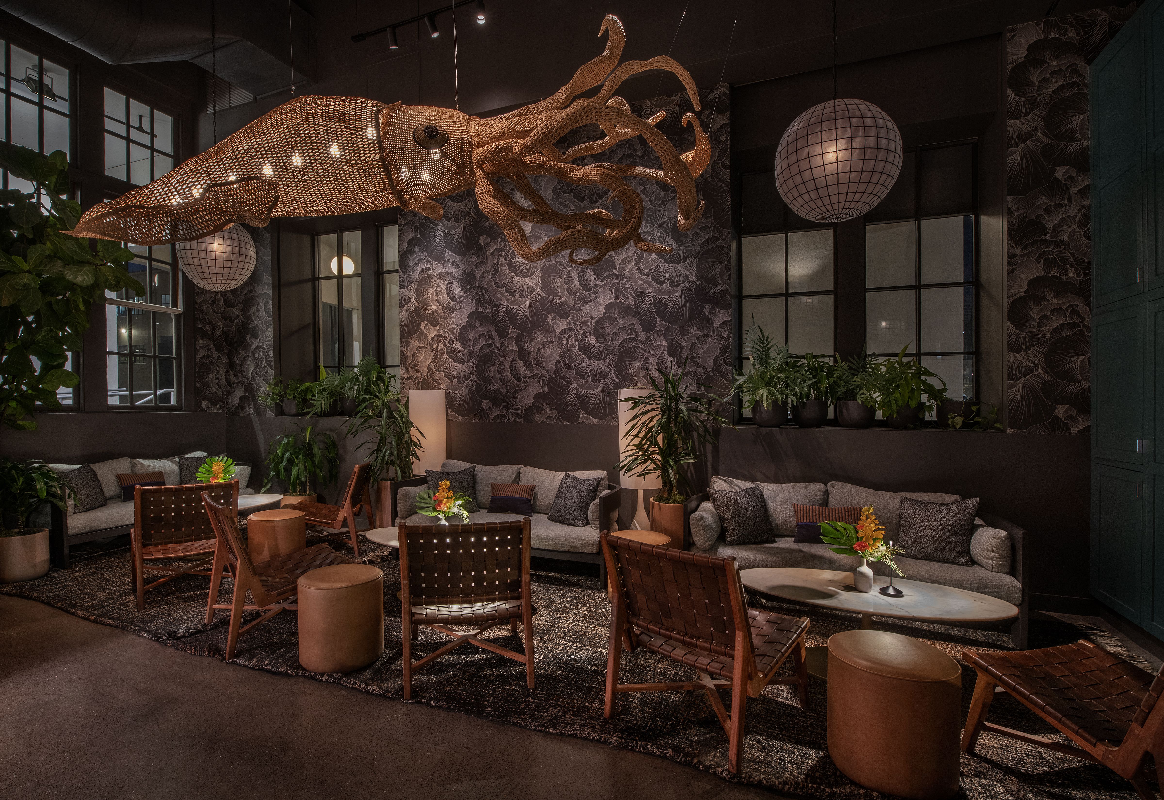 The inside of a restaurant with couch seating and a large light fixture shaped like a jellyfish