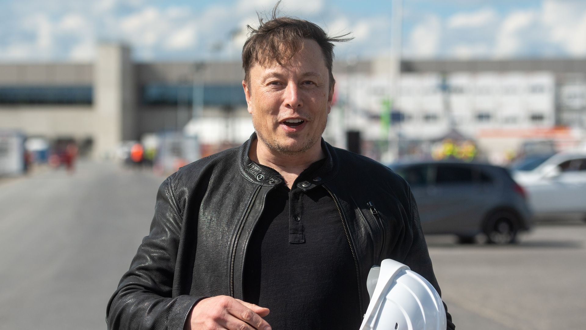 Elon Musk, Tesla CEO, stands on the construction site of the Tesla factory holding his hard hat in Berlin, Germany