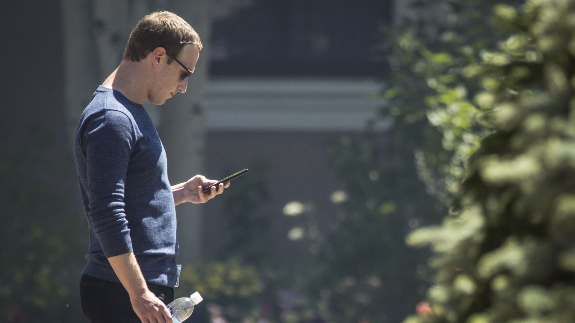 Mark Zuckerberg looks at his phone.