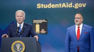 President Joe Biden speaks as Miguel Cardona, US secretary of education, right, listens in the Eisenhower Executive Office Building in Washington, D.C., US, on Monday, Oct. 17, 2022.