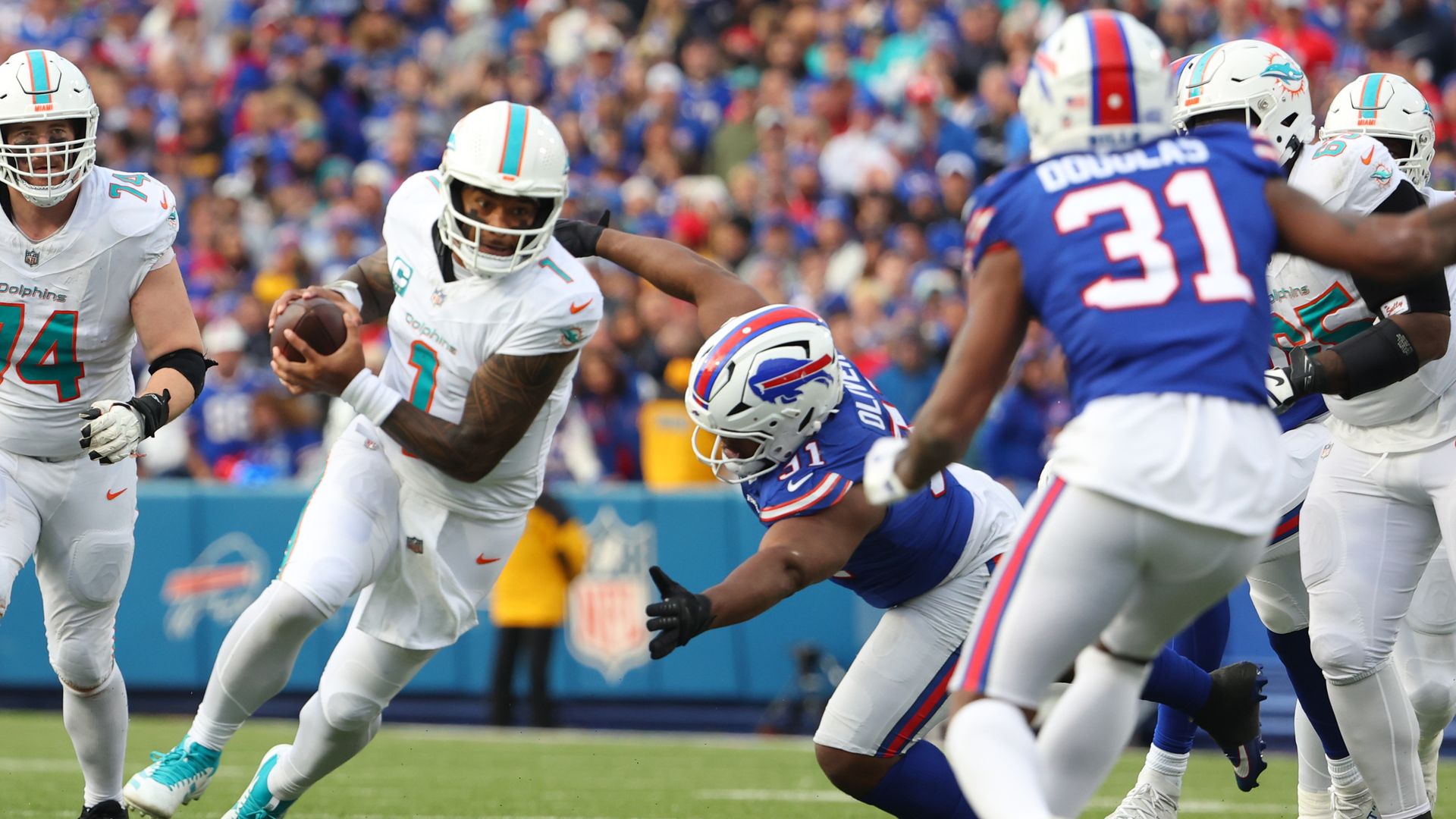 Dolphins quarterback Tua Tagovailoa runs past a defender