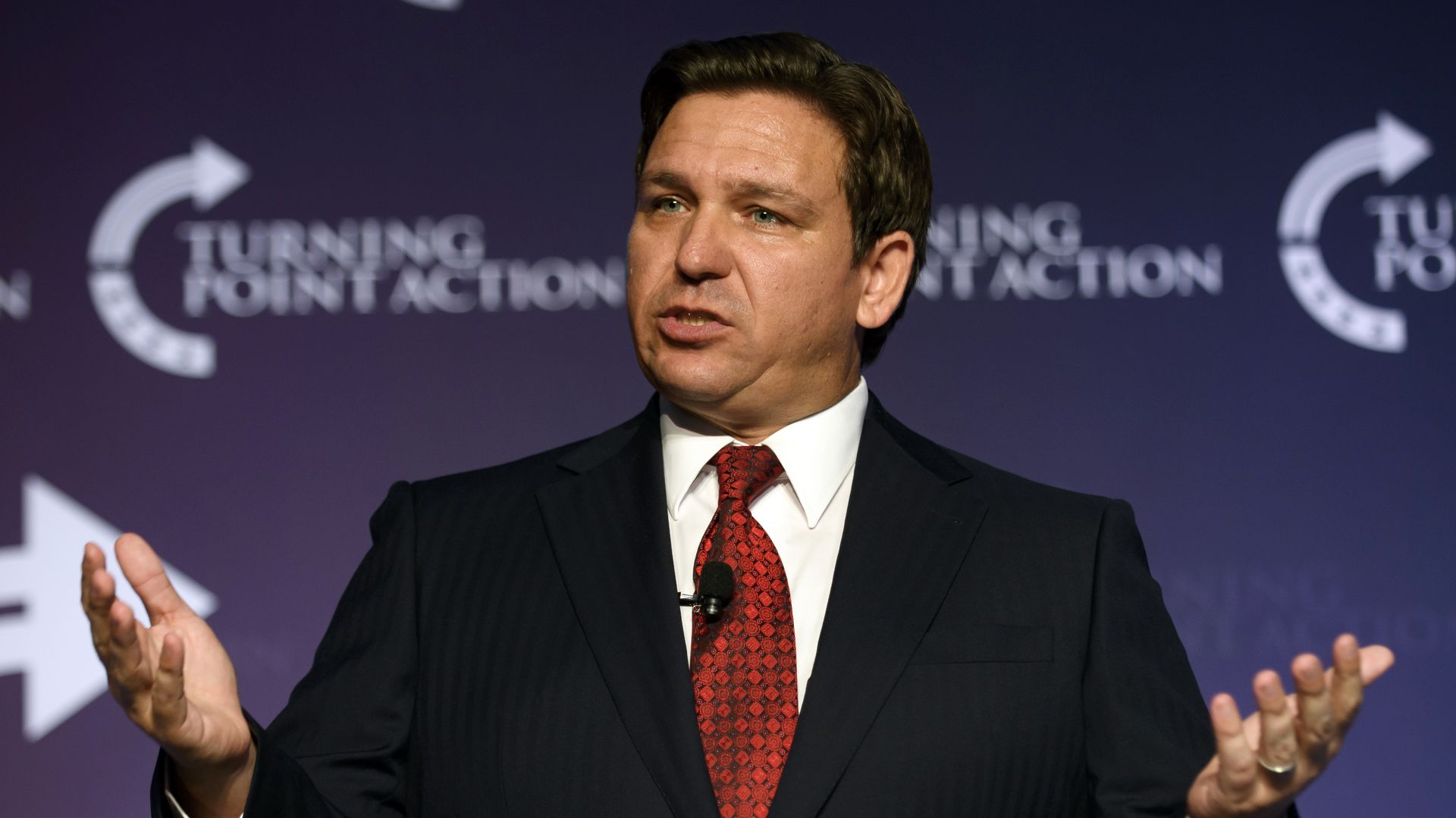 Photo of Ron DeSantis speaking while raising his hands