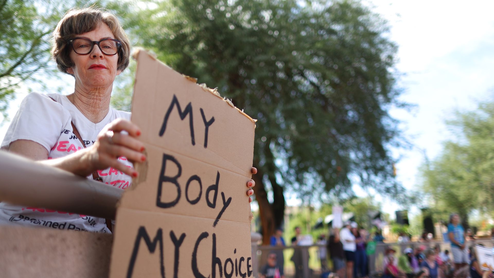 A protester holds a sign reading 'My Body My Choice' at a Women's March rallyoutside the State Capitol on October 8, 2022 in Phoenix, Arizona.