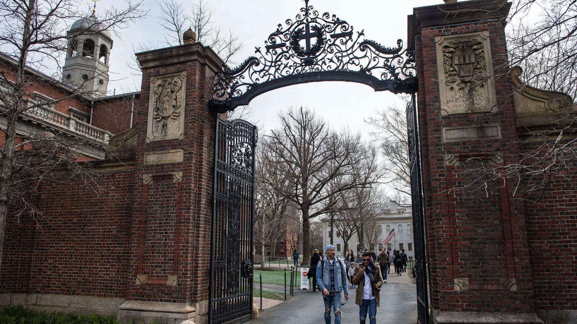 People walk through Harvard gates