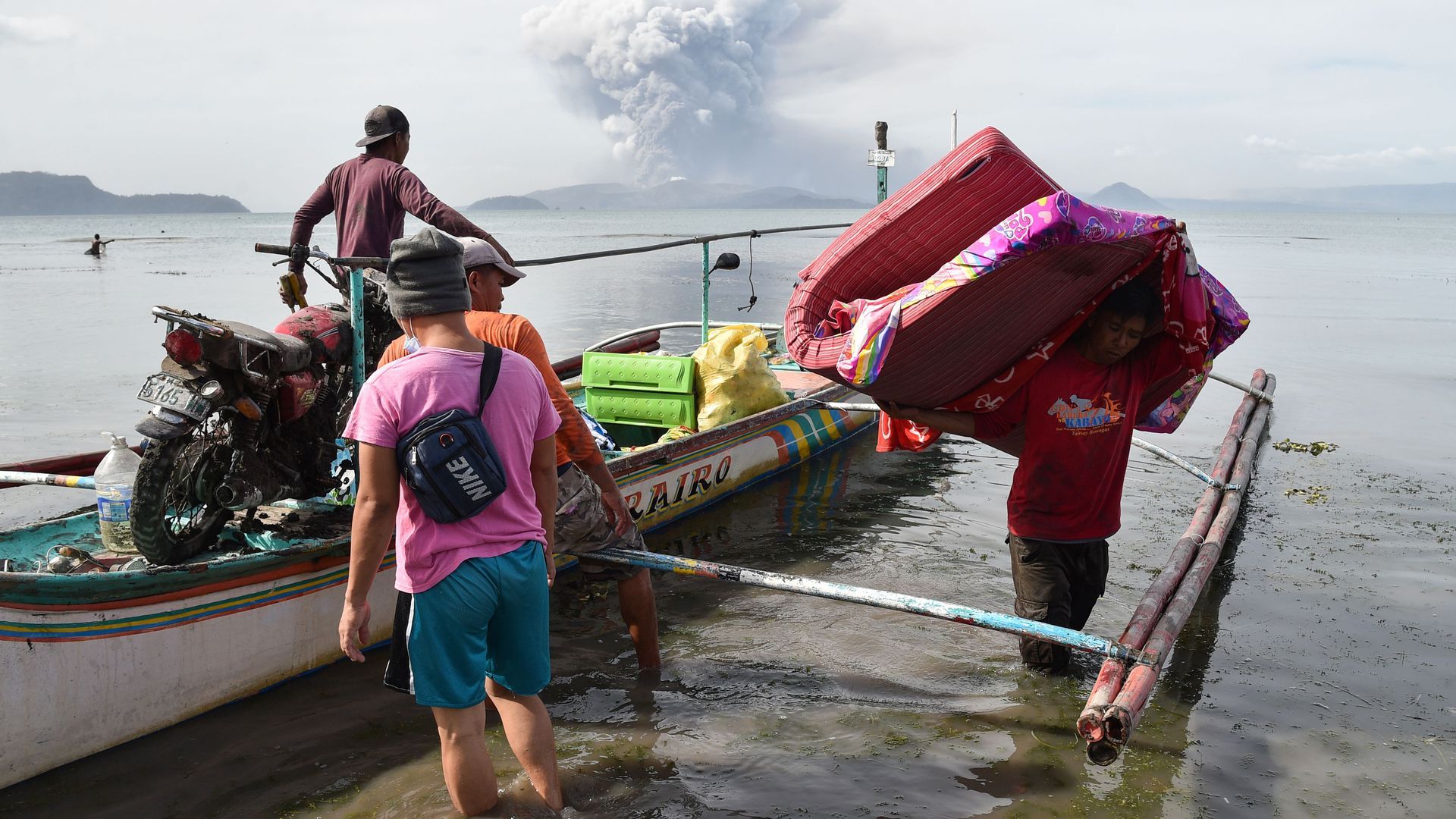 Residents evacuate from their home at the foot of Taal Volcano, as seen from Tanauan town in Batangas province, south of Manila