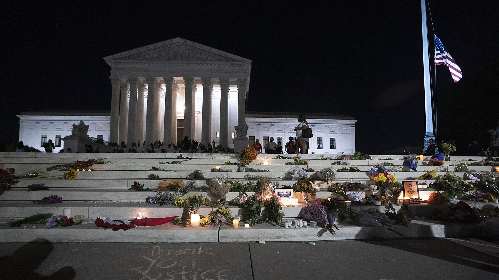 The flag flies at half-staff as people mourn on the Supreme Court steps last night.