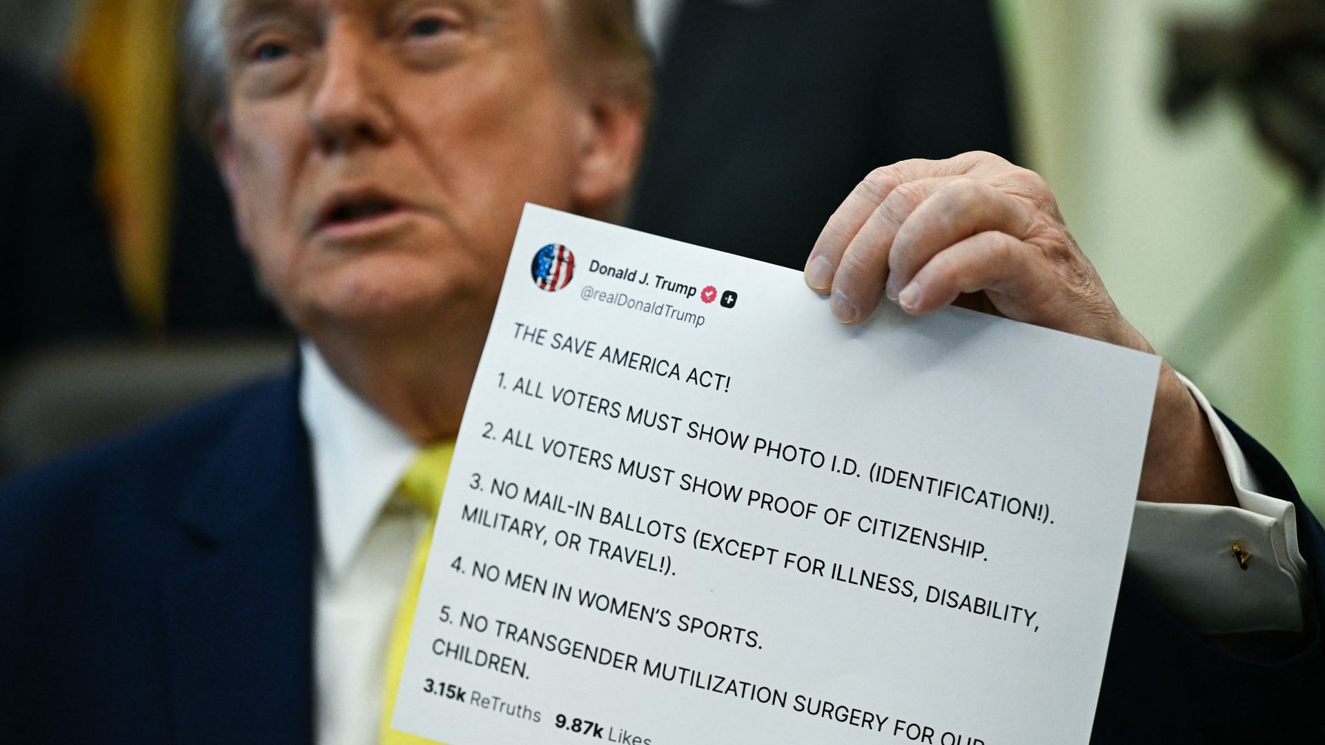 Trump holds up a printout of bullet points of the SAVE America Act.