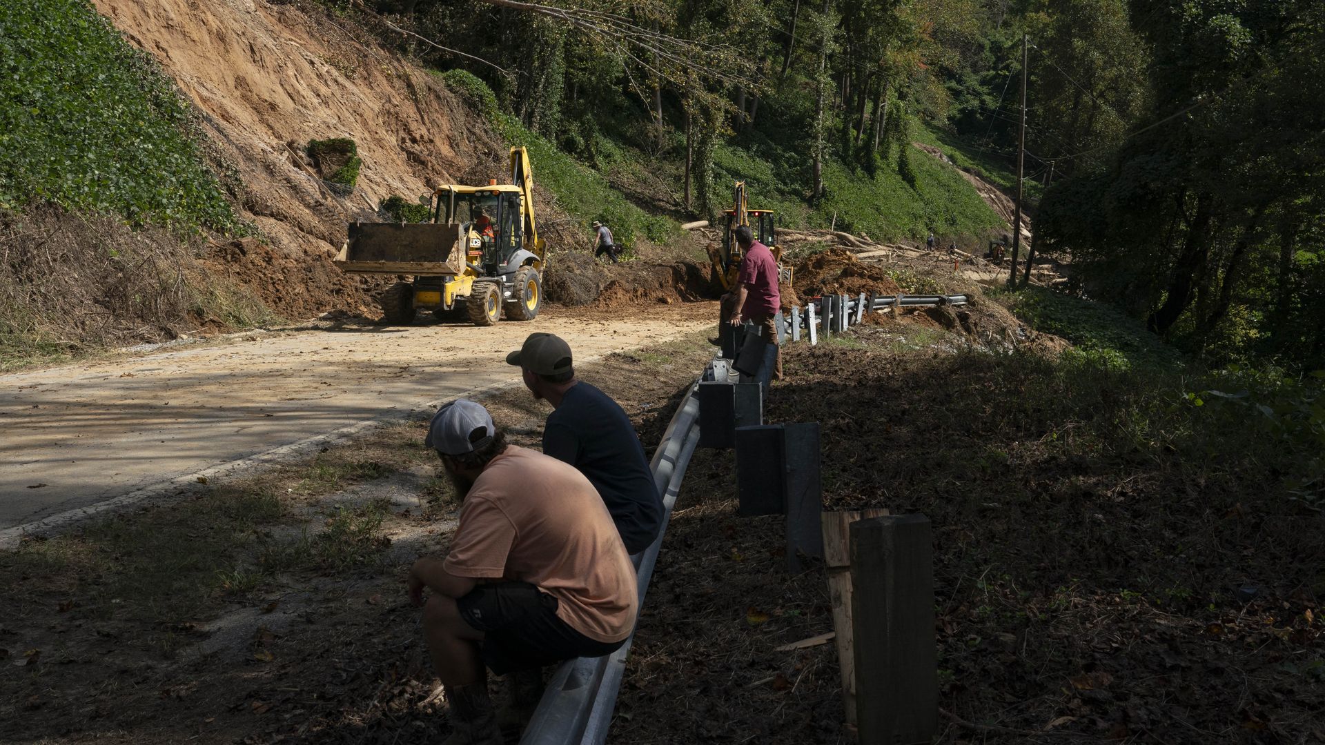 Workers clear a damaged road in Bat Cave, North Carolina, on October 3, 2024, after the passage of Hurricane Helene. 