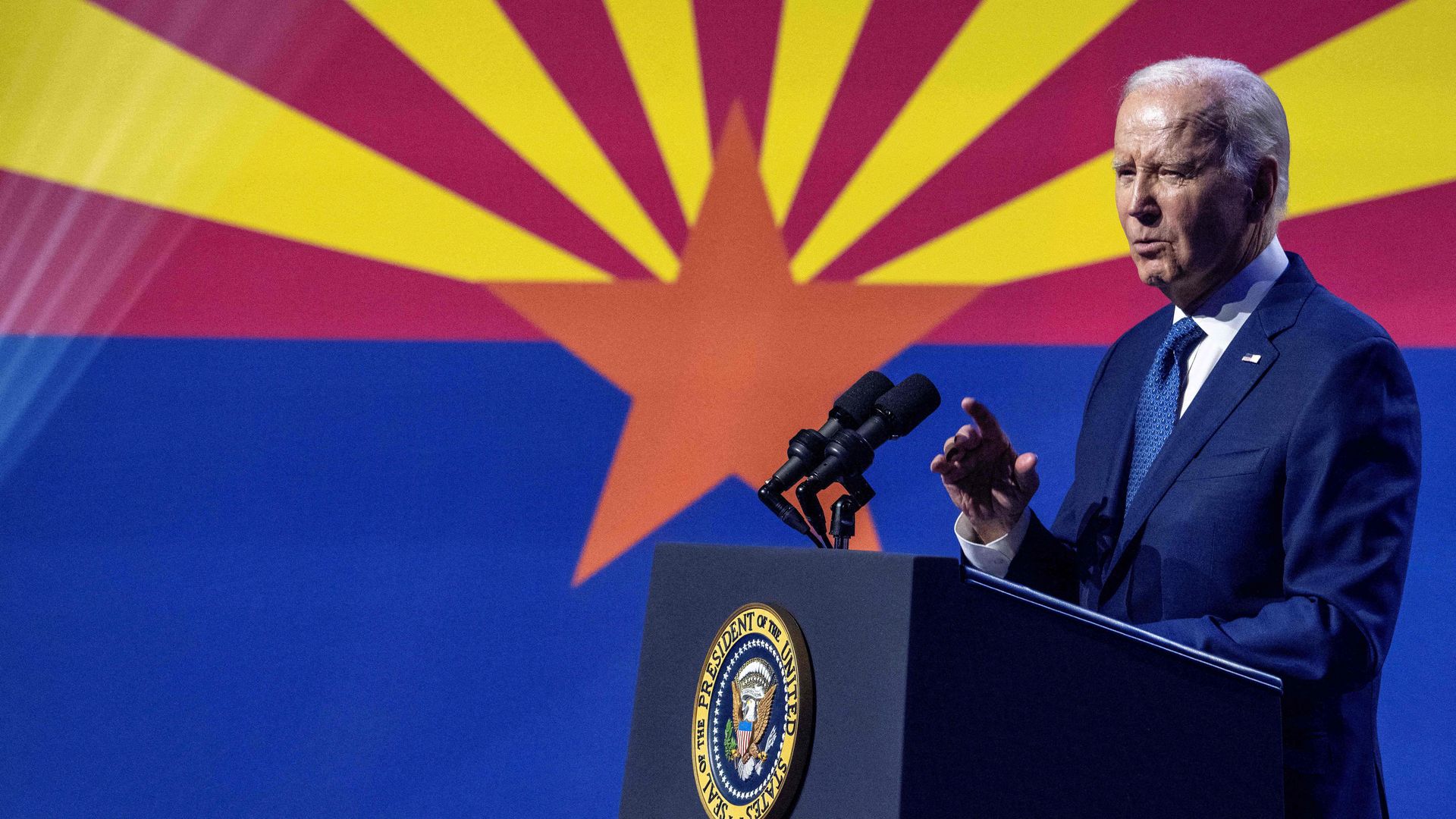 Joe Biden at a podium with the Arizona flag in the background. 