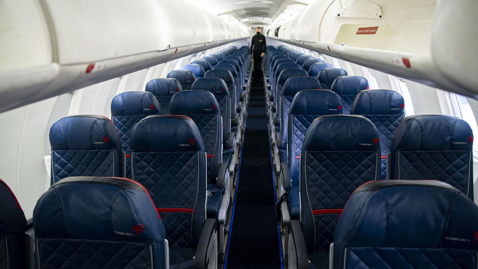 The interior of a Delta airplane, with blue quilted seats.