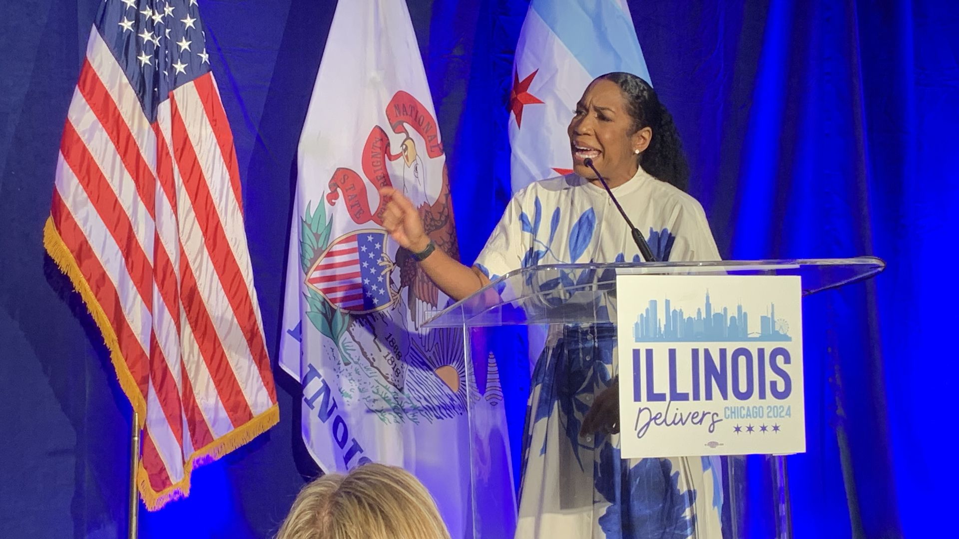 Photo of a woman speaking behind a podium 