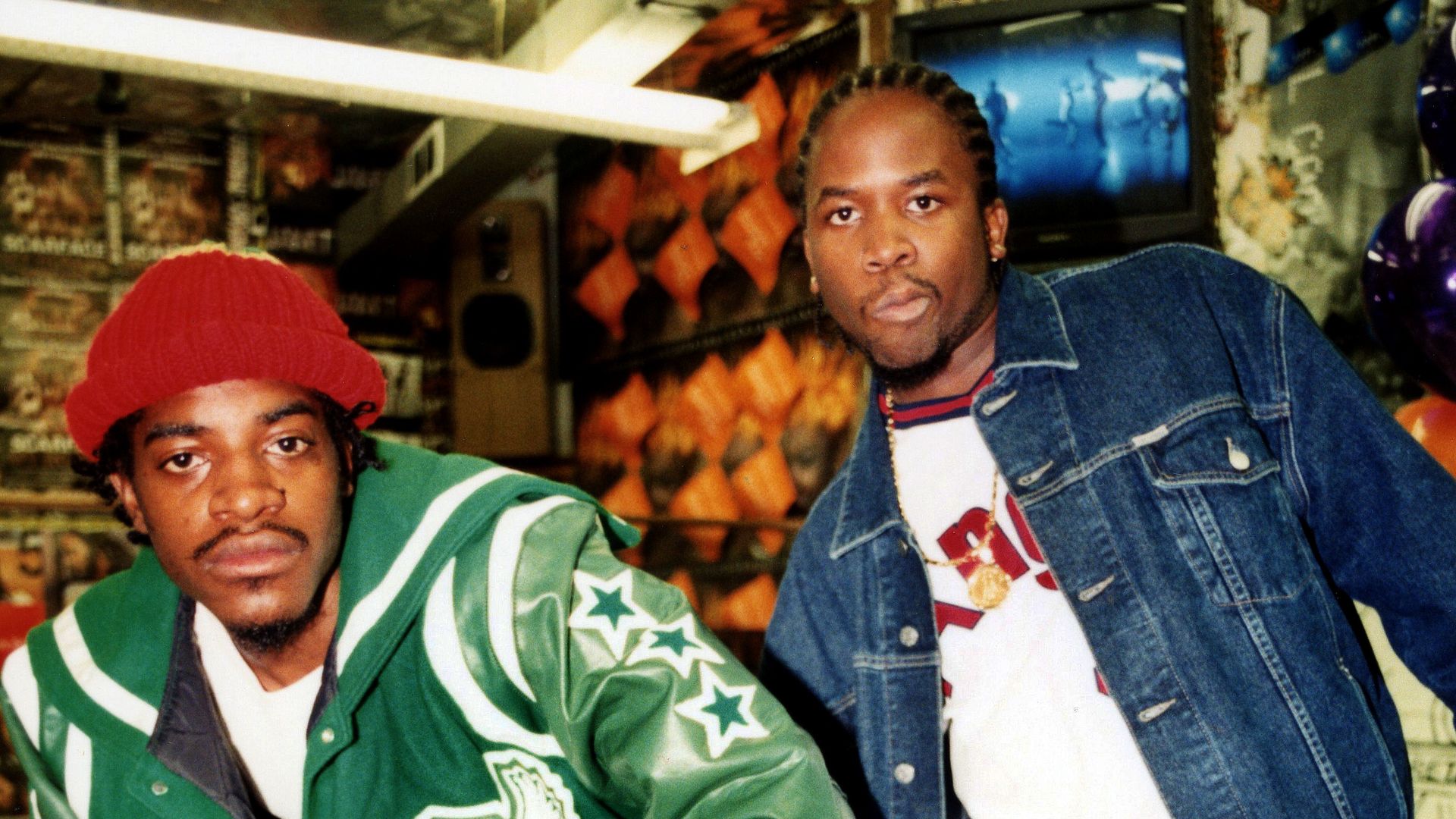 Andre 3000 and Big Boi out Outkast pose for a photo in colorful clothing. 