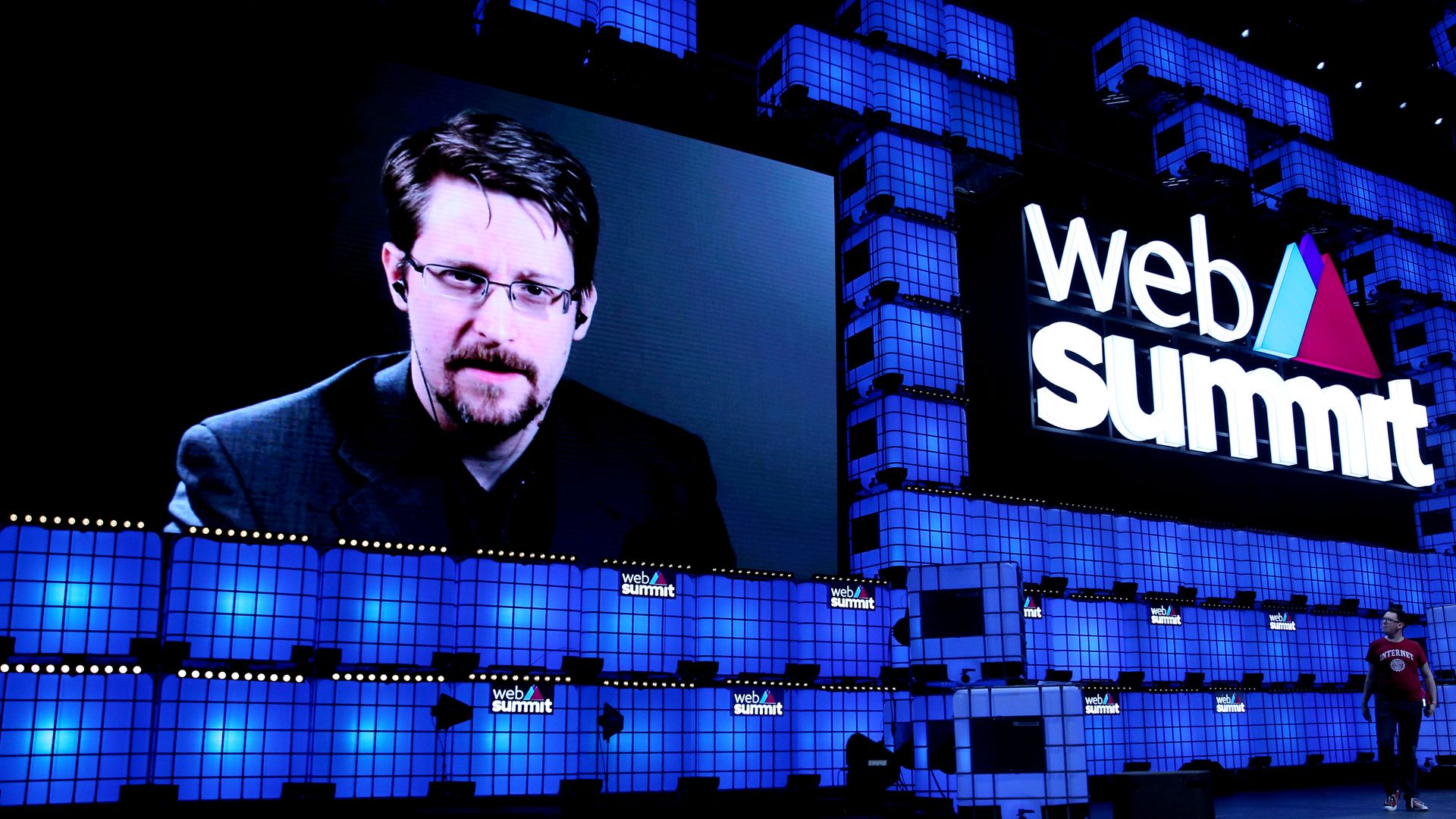Snowden is picture on a screen next to the Web Summit logo