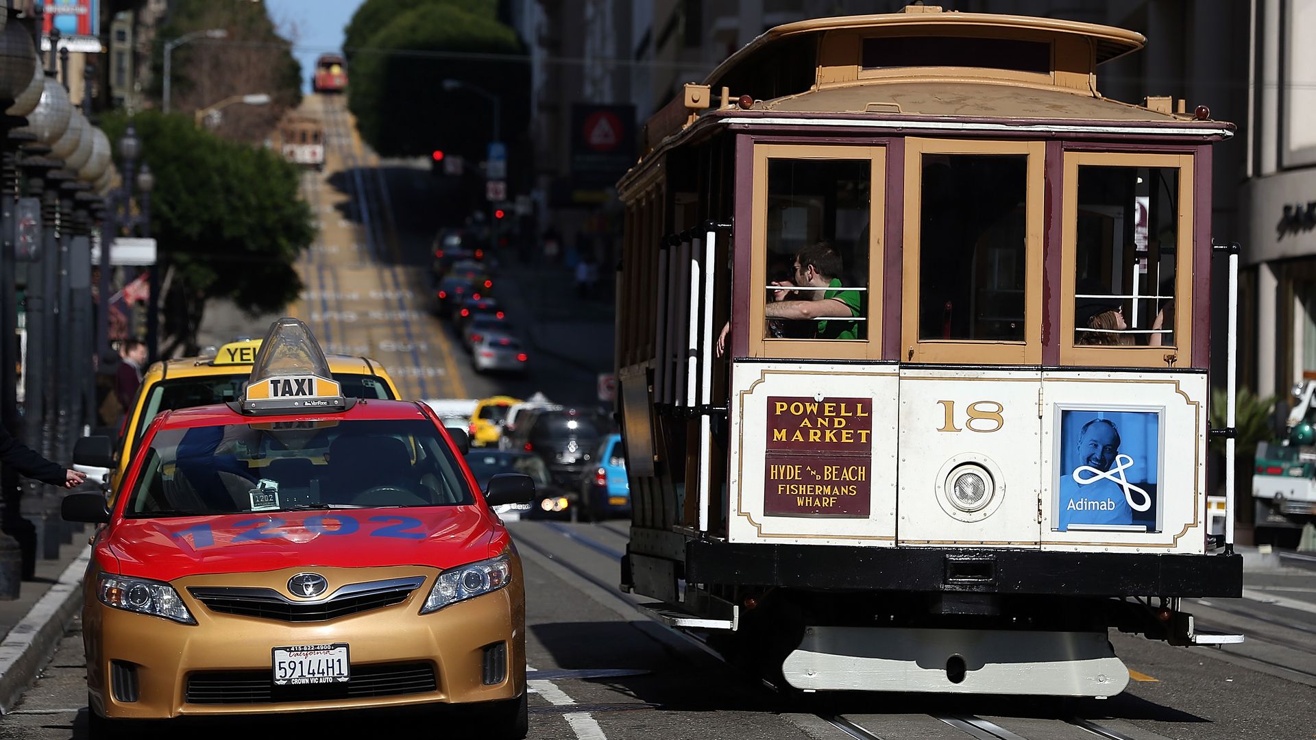 A Cable Car passes a line of taxicabs as they wait for fares in front of the St. Francis Hotel on January 21, 2014 in San Francisco, California. 