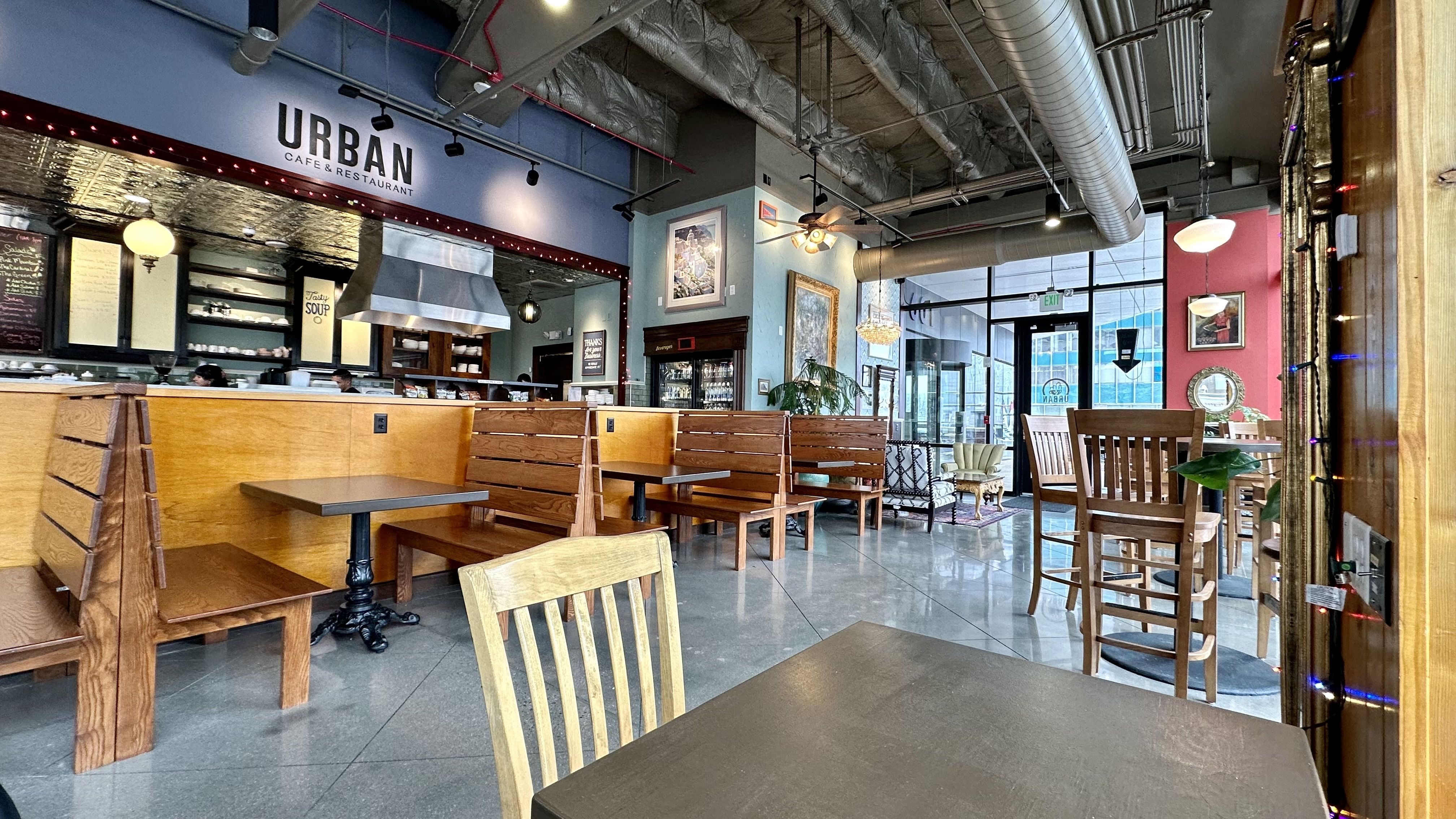 A photo of the interior of Urban Cafe, featuring tables and chairs and lots of large windows.