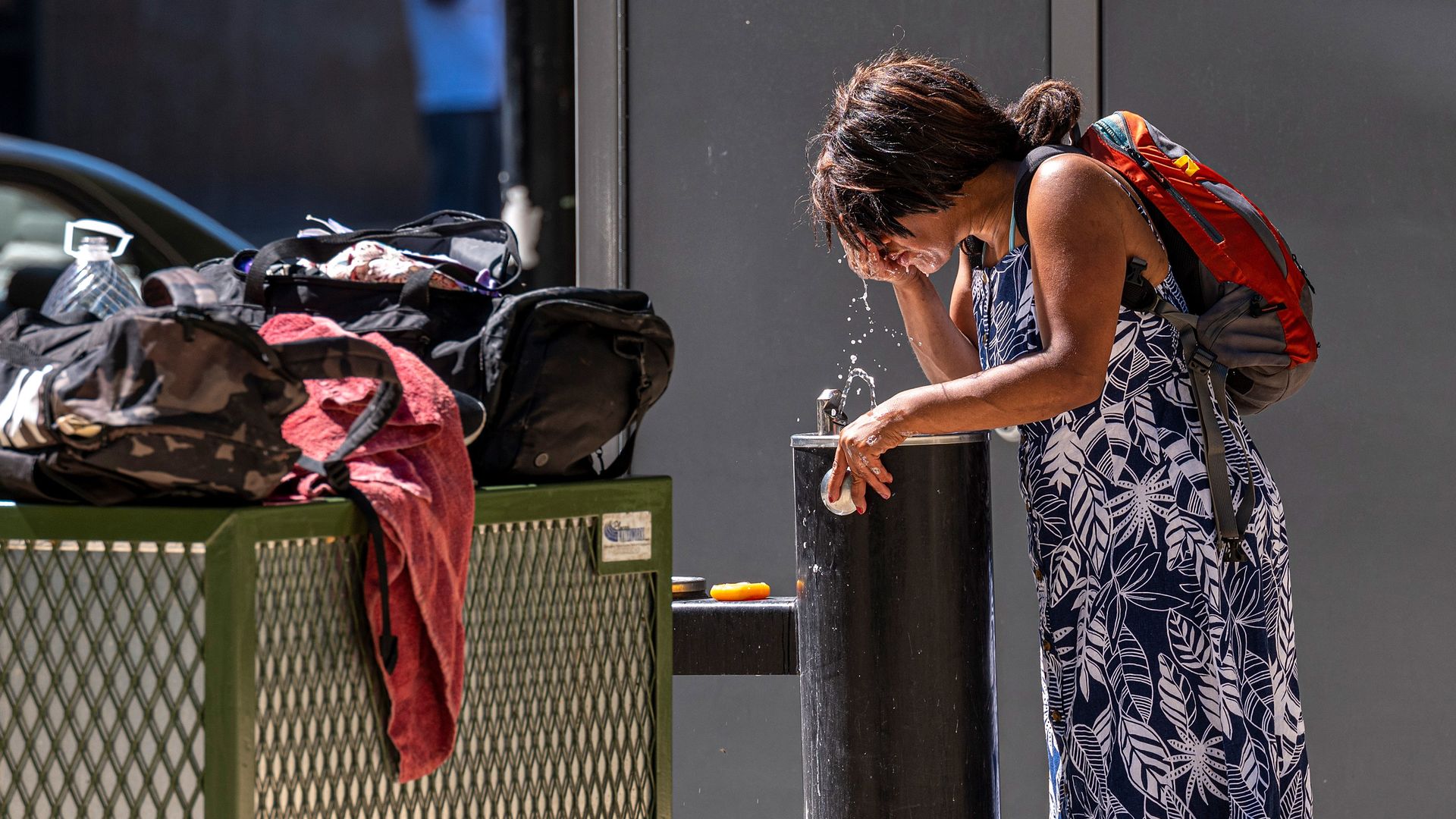 Woman cools off at a water fountain during a heat wave.