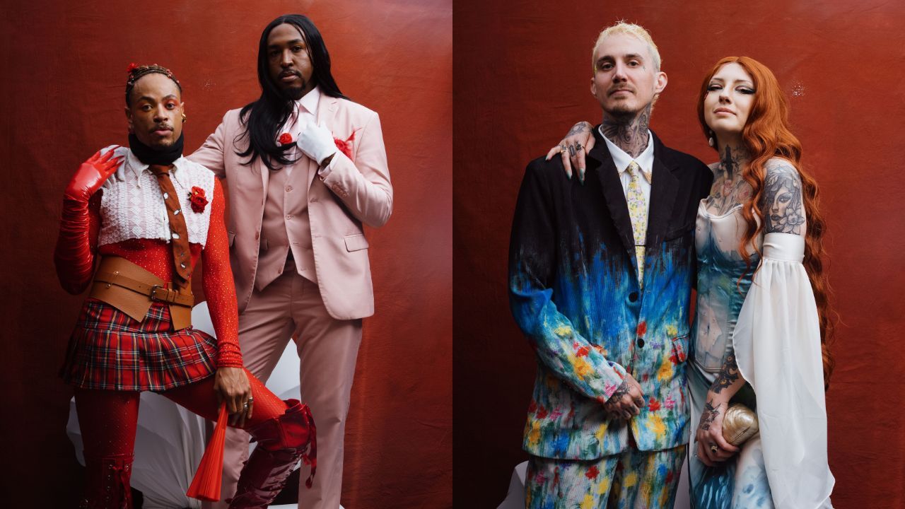 Two fashion duos against a red backdrop: left, a person in a red-and-white corseted outfit with a plaid skirt and red gloves beside a pale-pink suit wearer; right, a tattooed man in a blue-splattered suit with a red-haired woman in a white-blue gown.