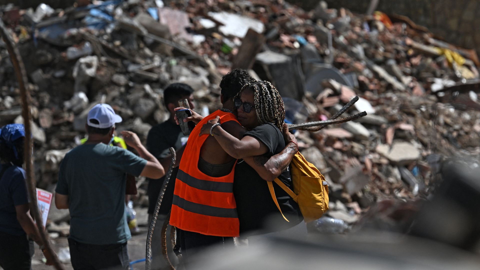 a photo of two people hugging next to rubble