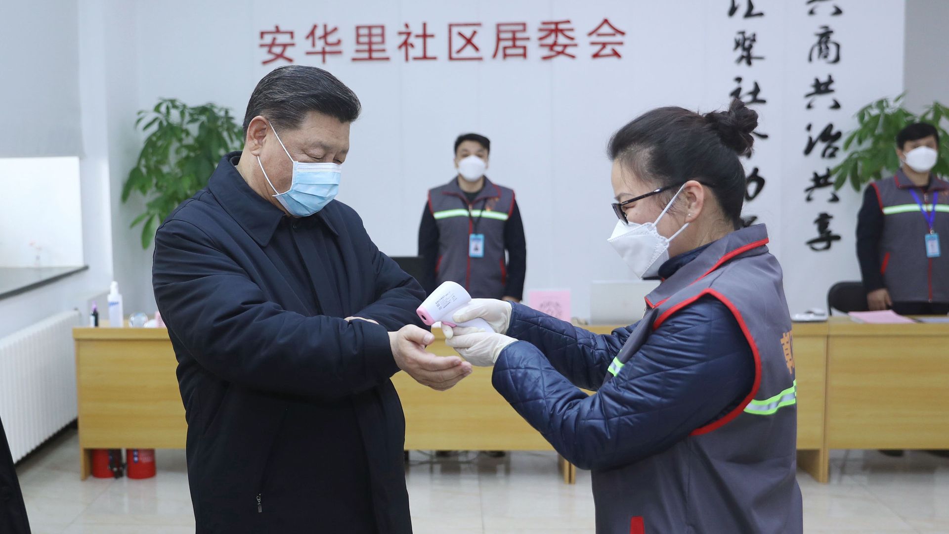 In this image, Xi Jinping wears a face mask and has his temperature read via scanning his wrist