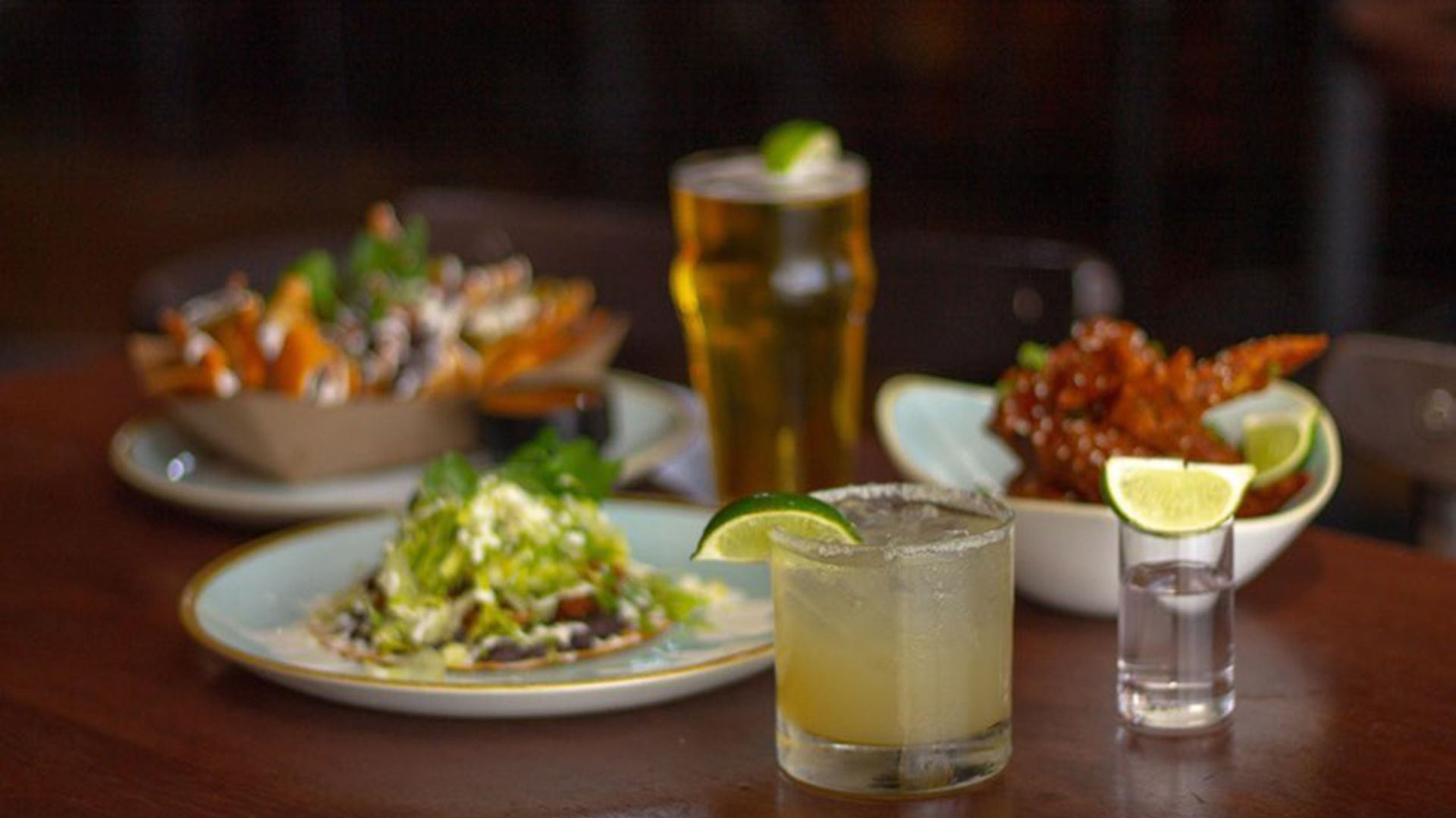 Cocktail, tequila shot, draft beer, and appetizers