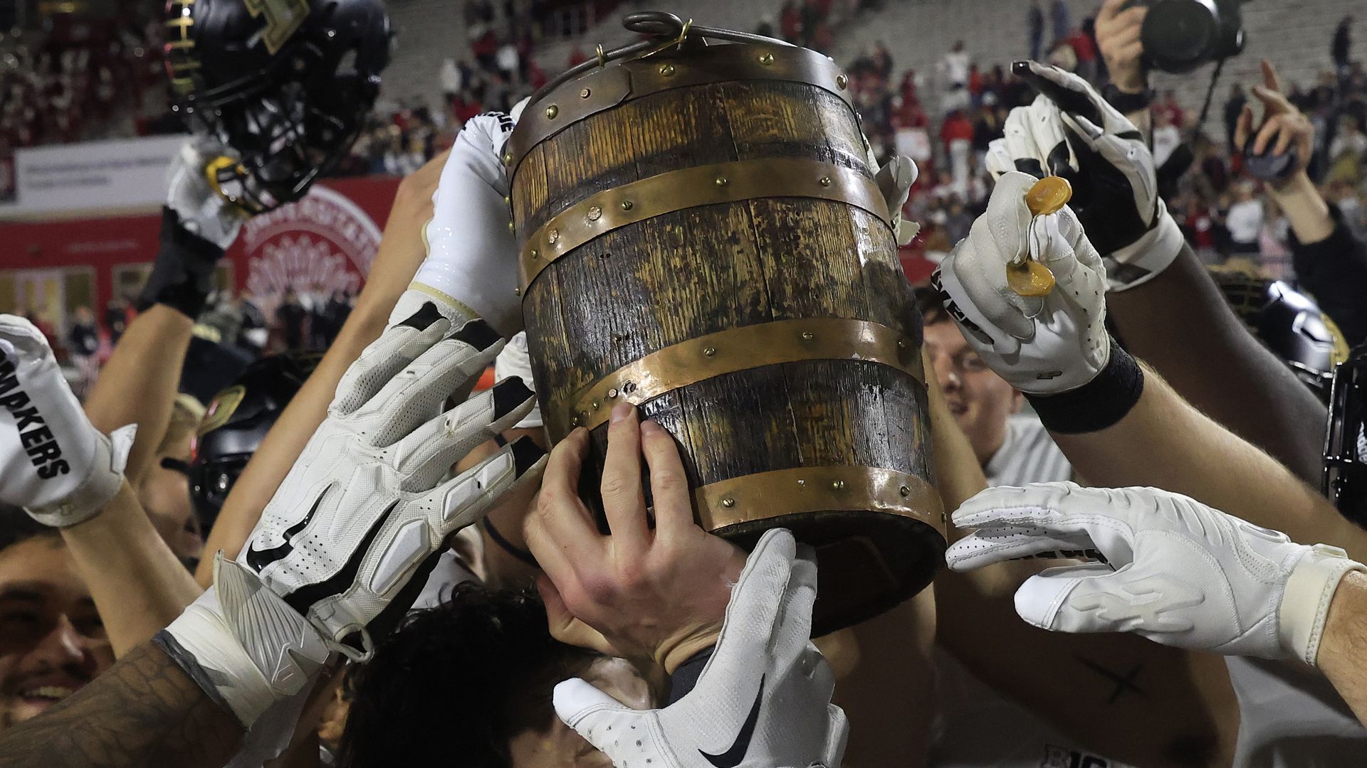 The Purdue Boilermakers hold up the Old Oaken Bucket after a win over the Indiana Hoosiers last year at Memorial Stadium in Bloomington.