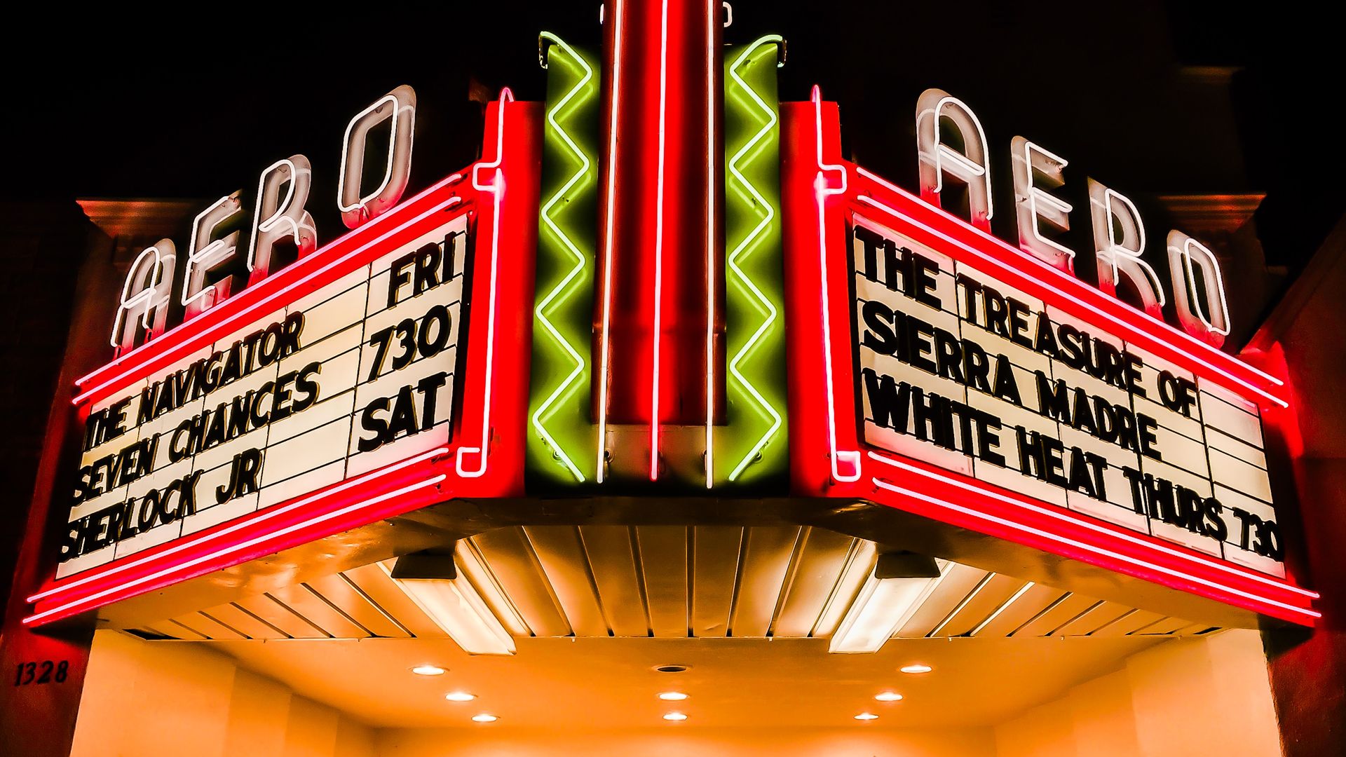 Neon movie marquee at night