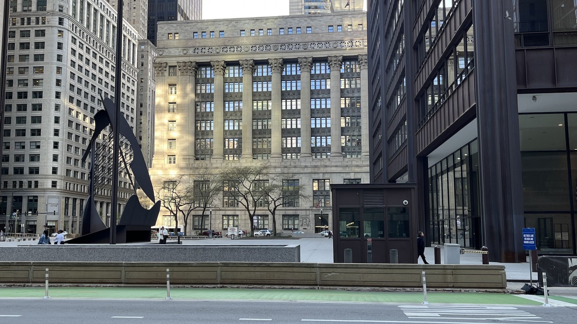 Daley Plaza  with a black modern office building on the right and a classical building in the background.