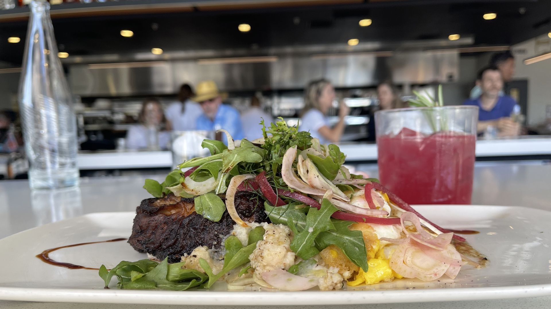 a plate of food with a view of people eating at the counter
