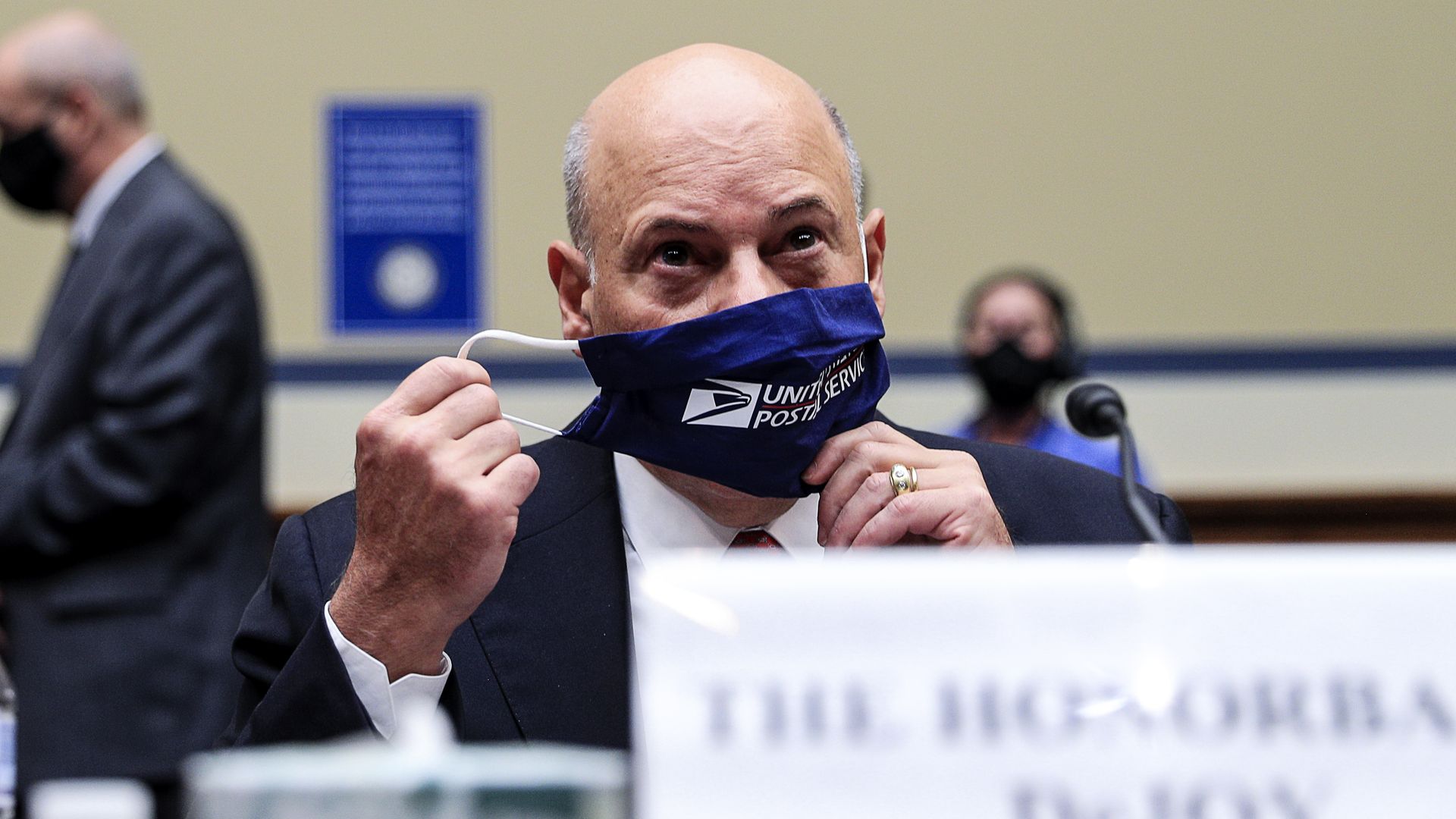 Postmaster General Louis DeJoy adjusts his face mask during a congressional hearing