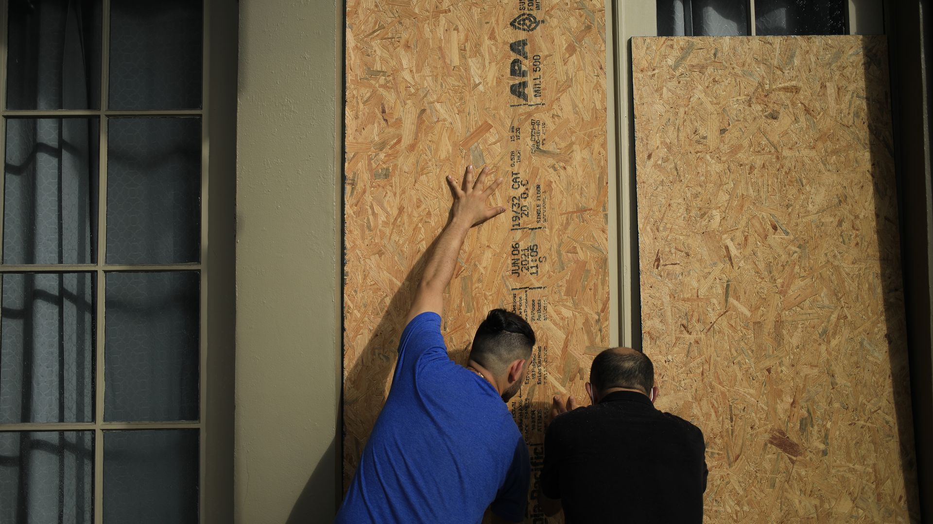 Picture of people boarding up a building in New Orleans
