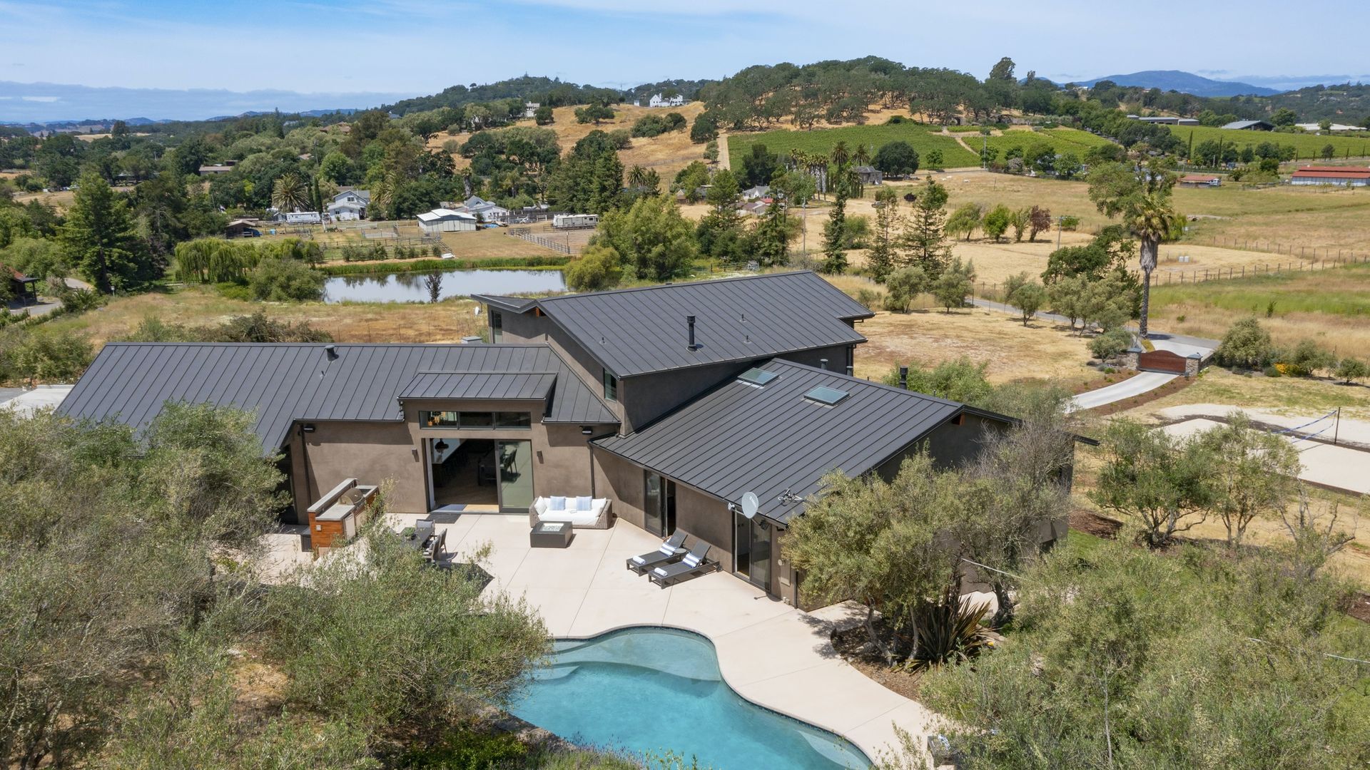 An exterior aerial view of a luxury home and pool property in the Napa Valley region of California.