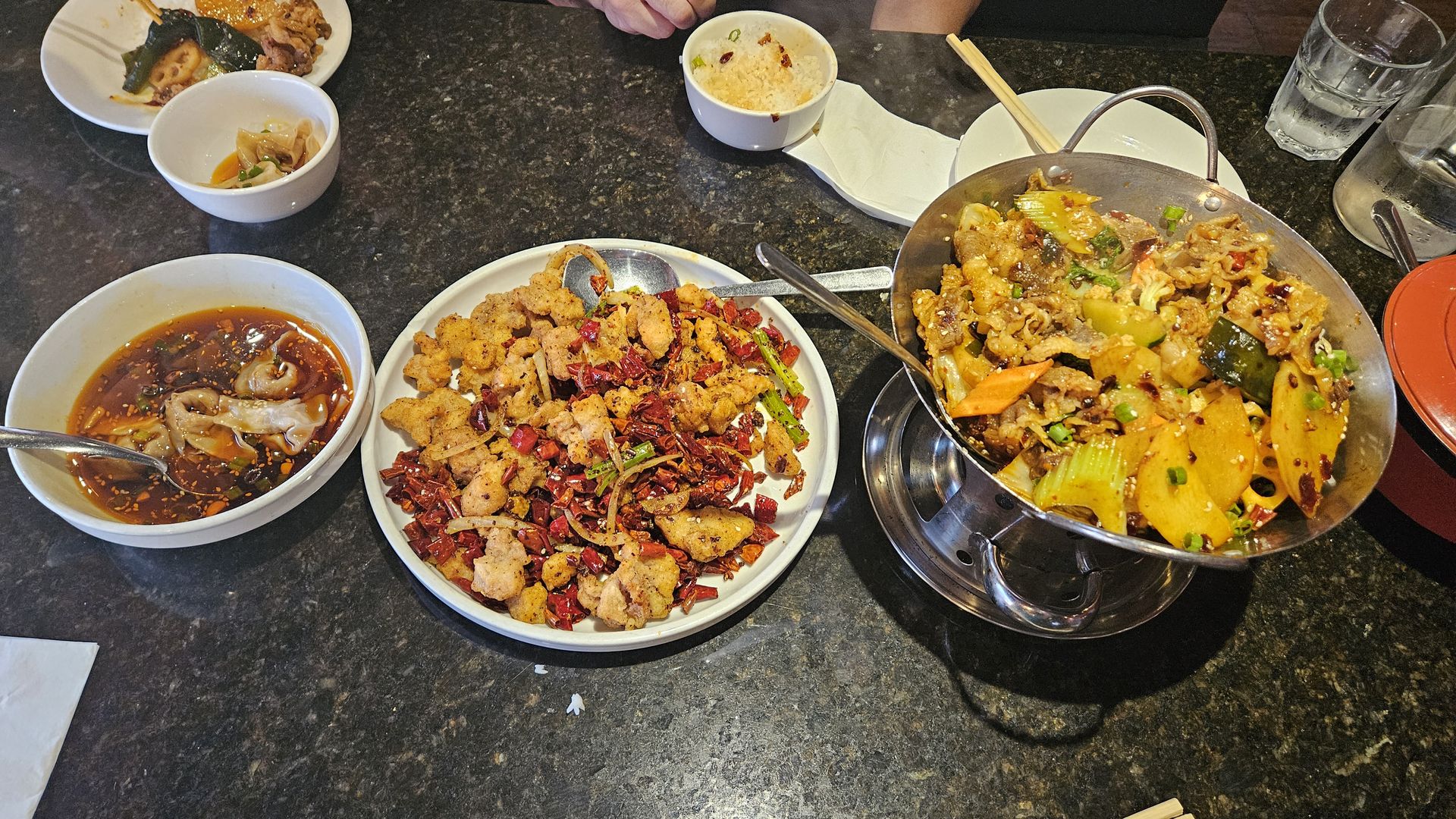 Dumplings, spicy chicken and beef tossed with noodles are displayed on a table at Yummy Spicy in Doraville.