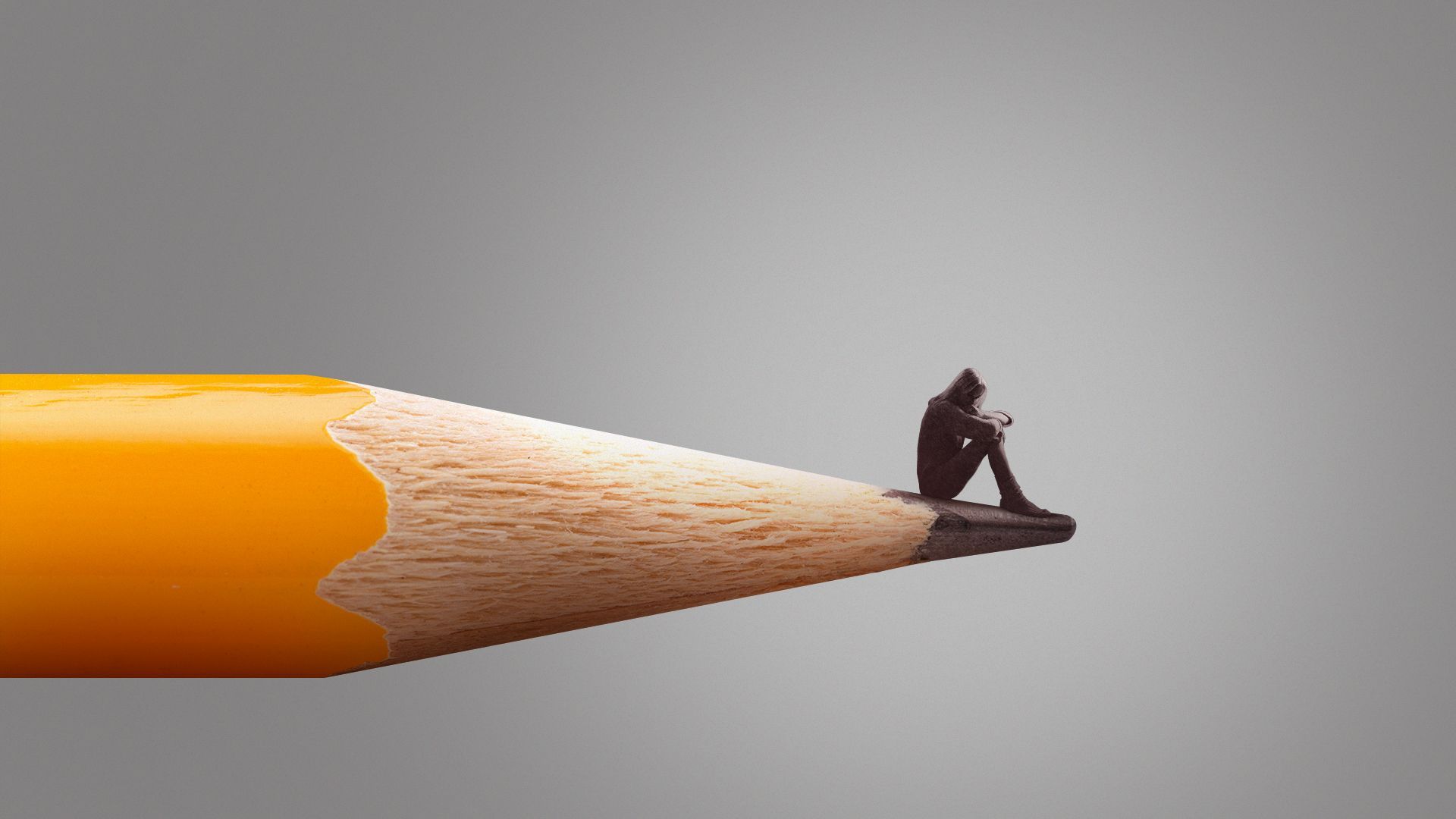 Illustration of a person sitting somberly on the edge of a giant pencil