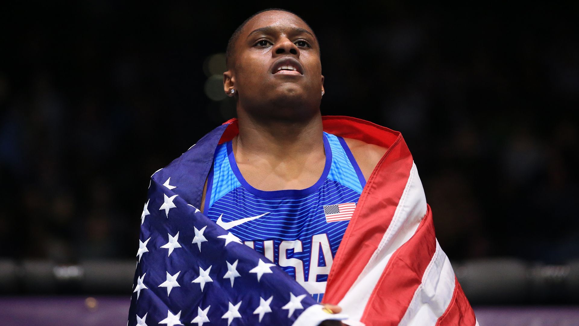 Christian Coleman at the IAAF World Indoor Championships wrapped in an American flag