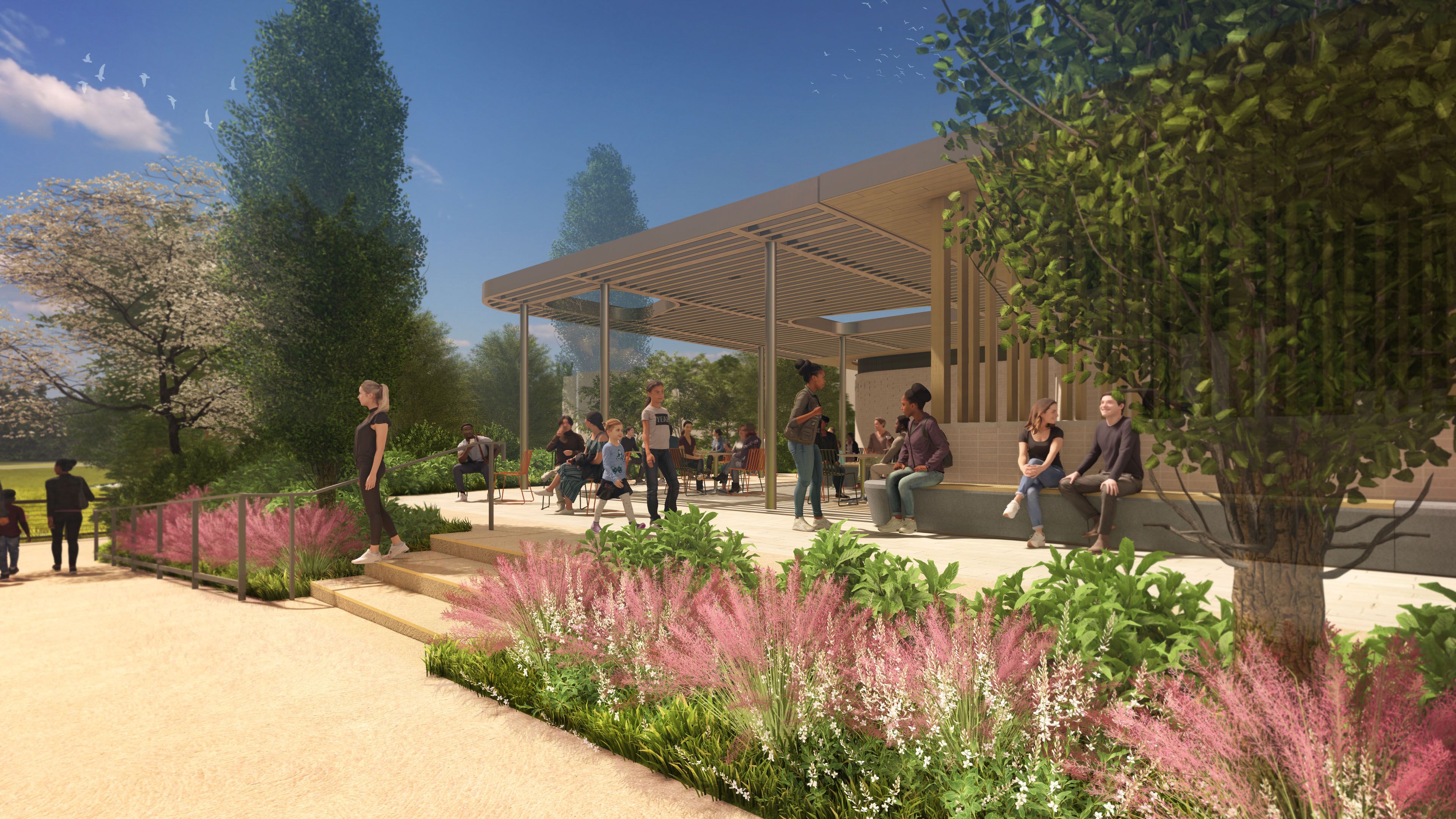 A sunny park with a modern slatted-roof pavilion, people seated and standing, lush trees, pink flowers, and a clear blue sky with birds in the distance.
