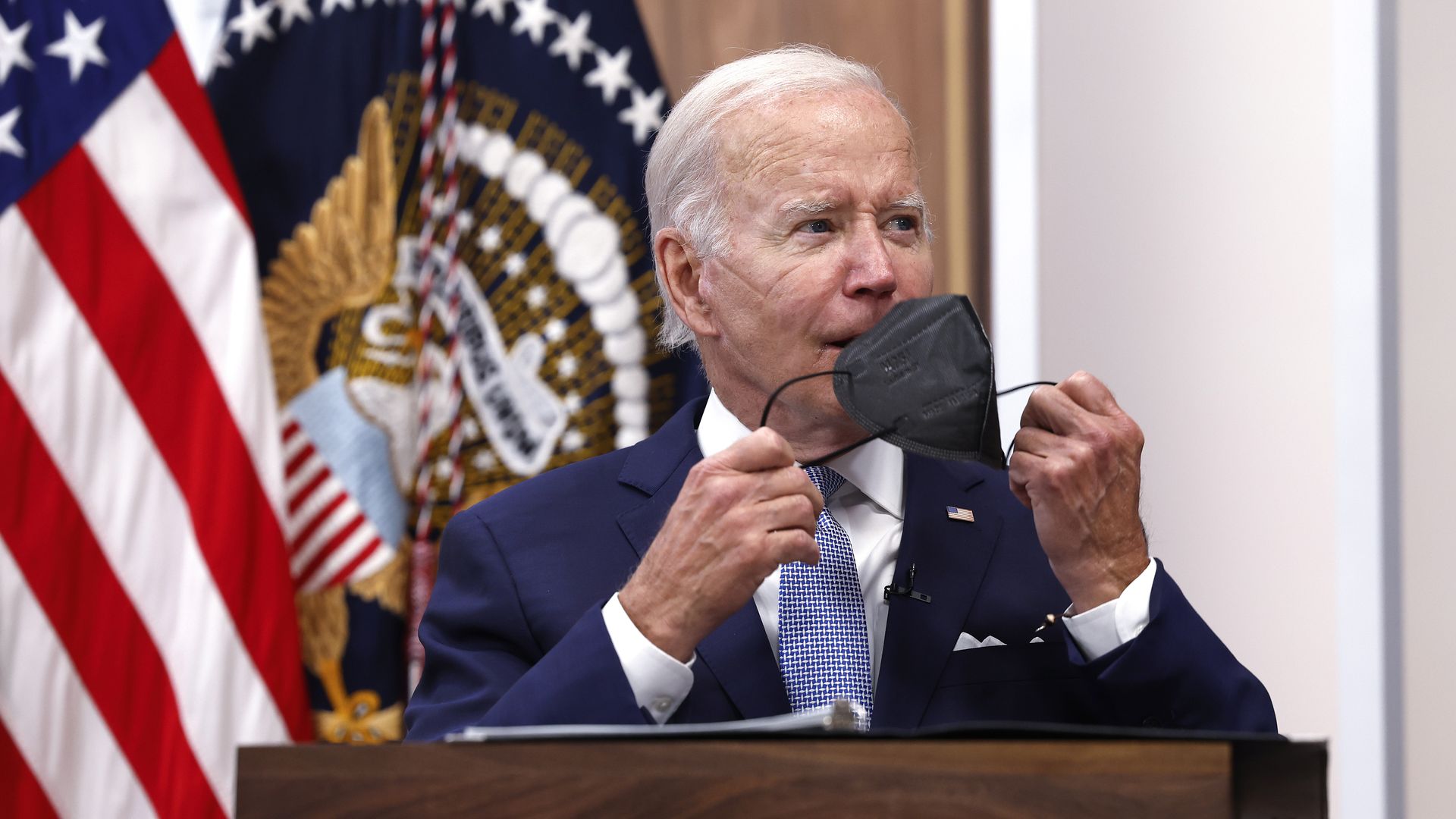 President Joe Biden takes his face mask off.
