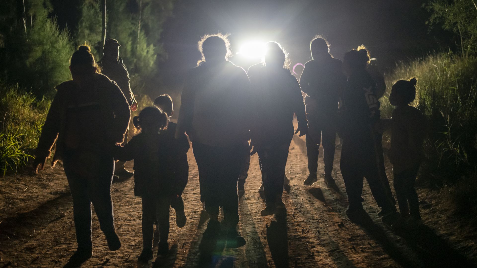 A group of undocumented immigrants walk toward a Customs and Border Patrol station after being apprehended at the U.S. border