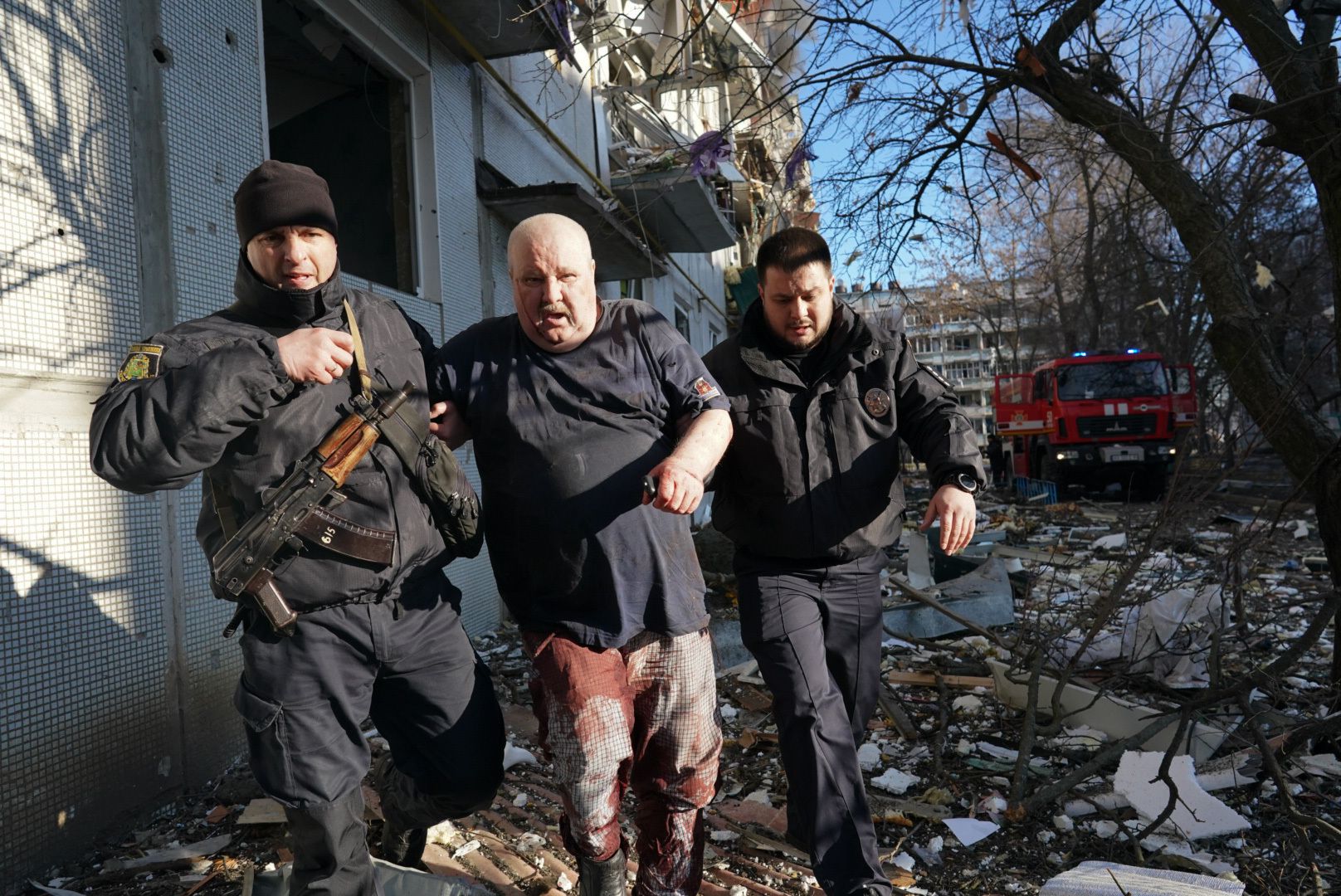 Ukrainian security forces accompany a wounded man after an airstrike hit an apartment complex in Chuhuiv, Kharkiv Oblast, Ukraine on February 24.