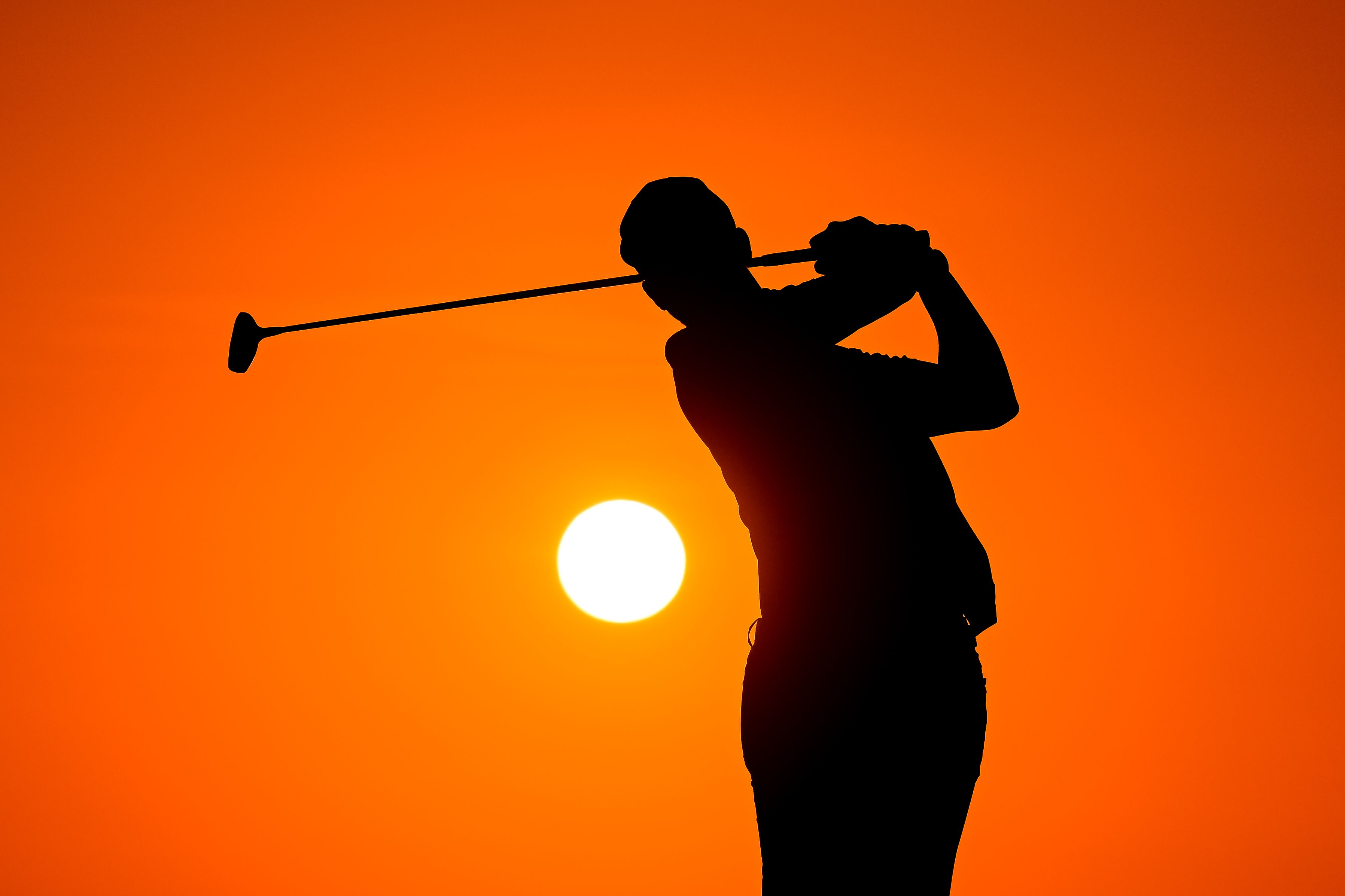 golfer silhouetted by the sun