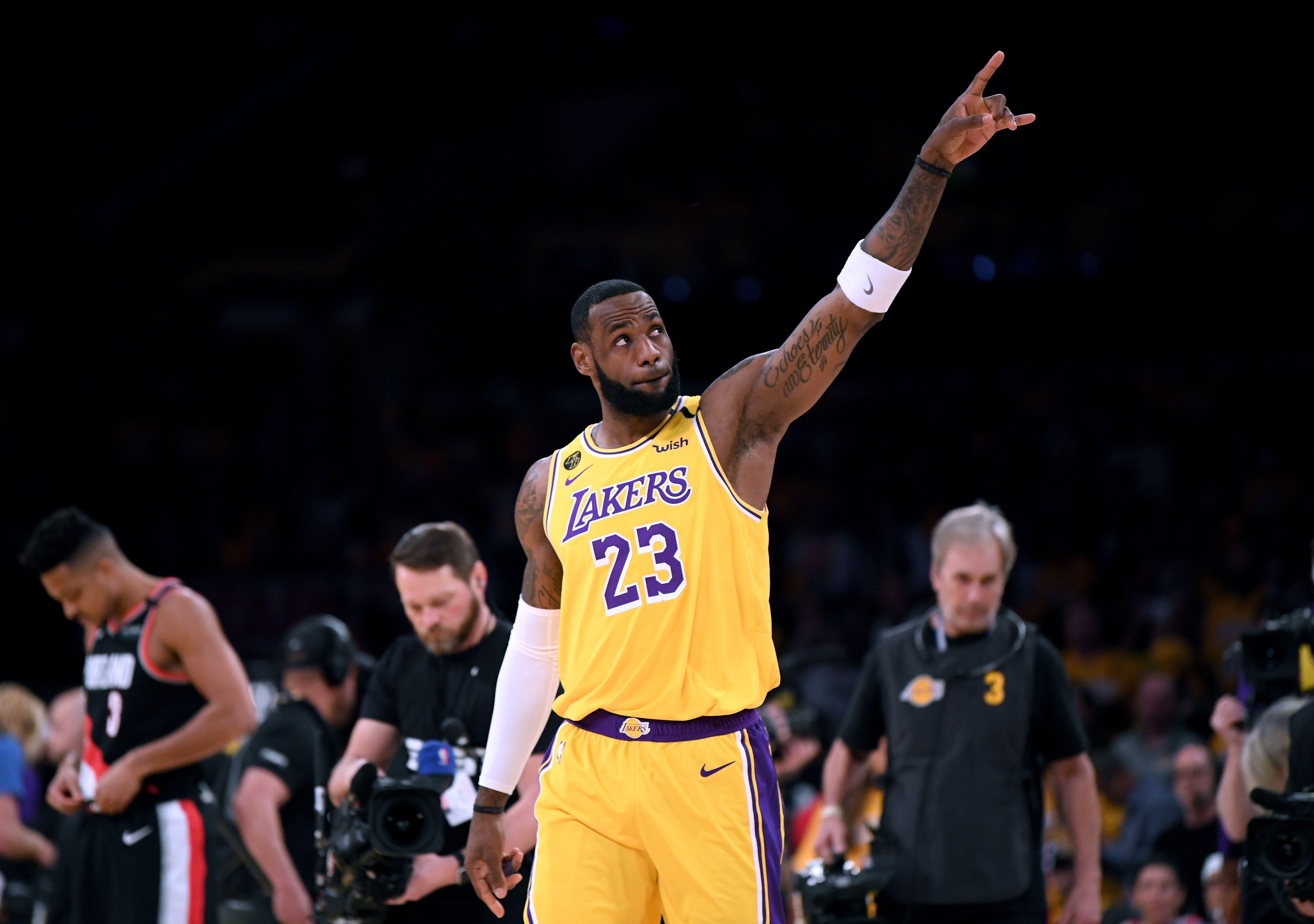 In this image, Lebron James points points upwards while on the court