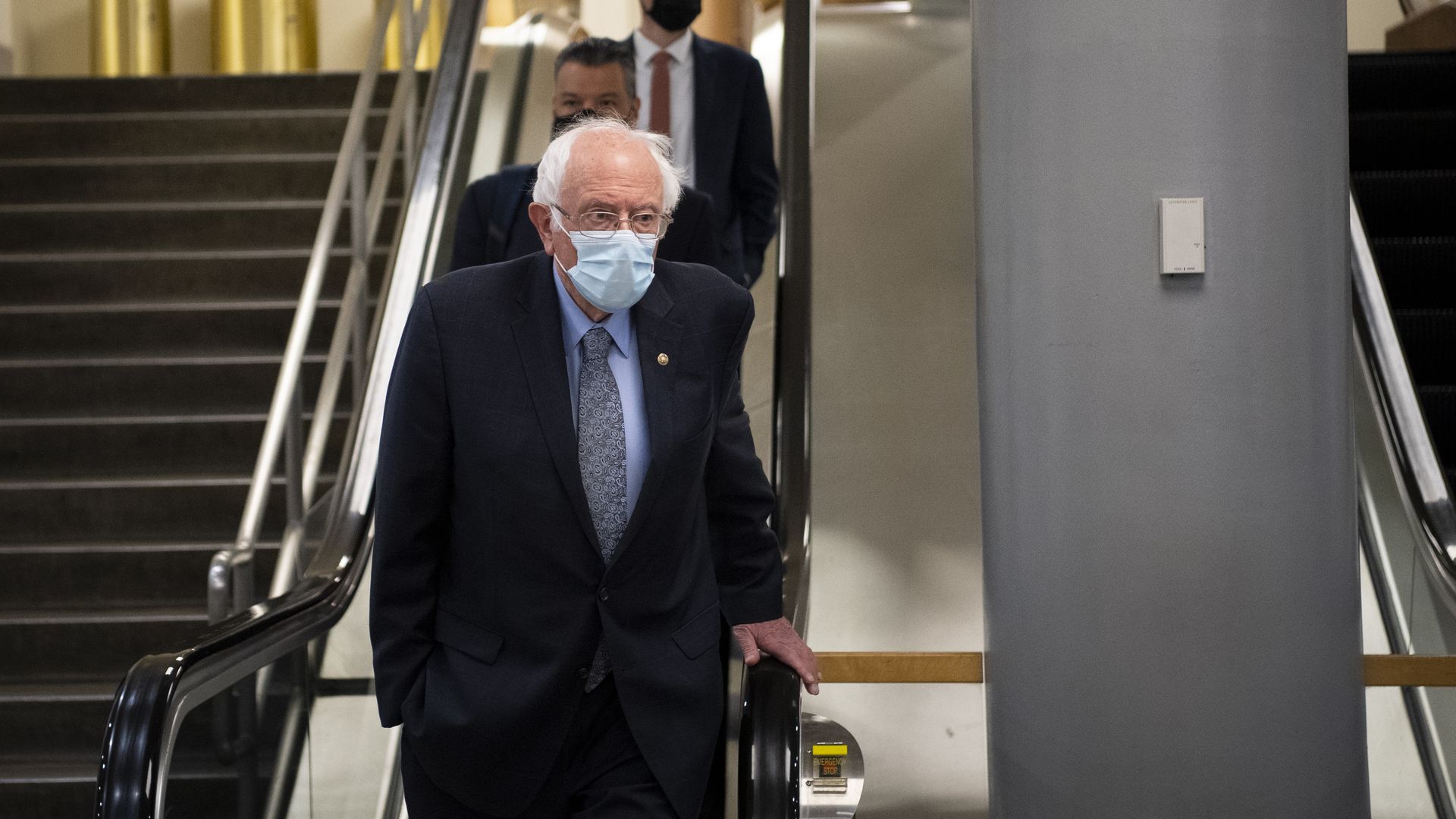  Sen. Bernie Sanders wears a mask while walking back from a vote on the Senate floor.