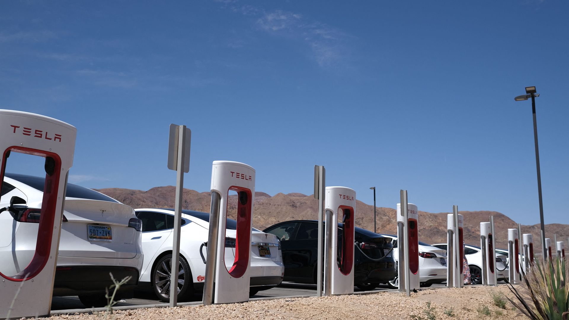Tesla cars sit at charging stations in Yermo, California, on May 14, 202