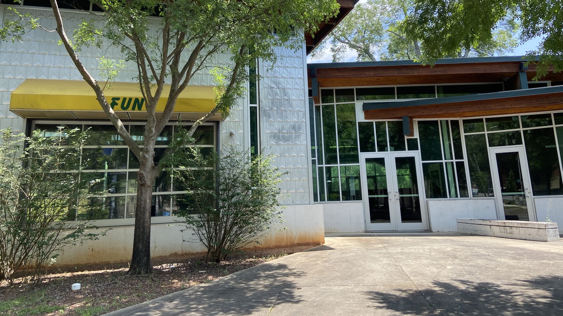 A photo of an empty and unused entertainment center with a yellow awning that says fun