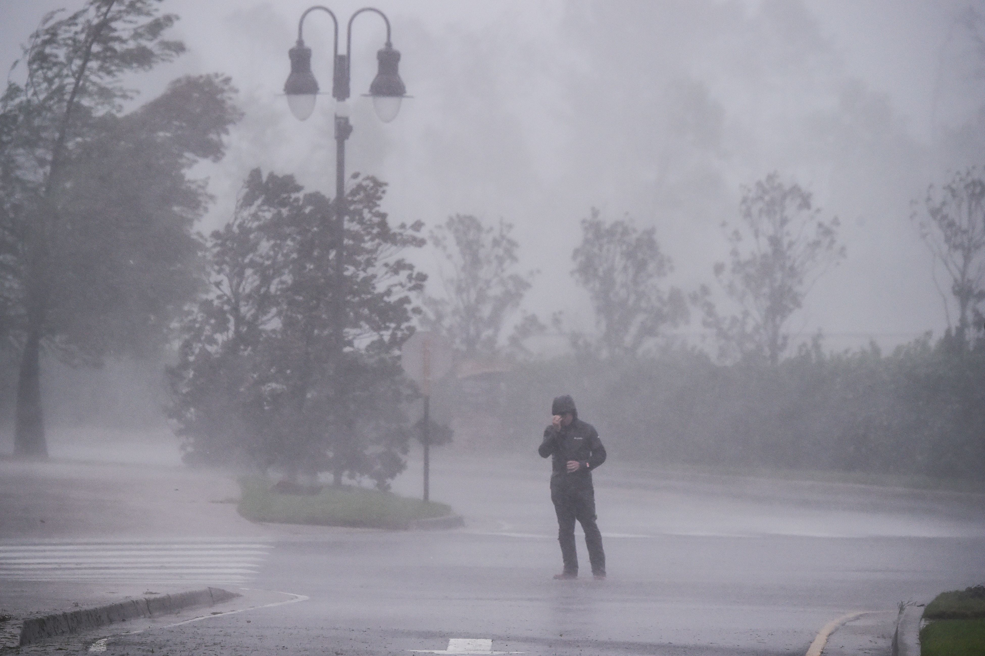  A reporter covers his face as he reports while Hurricane Delta makes landfall in Lake Charles, Louisiana on October 9