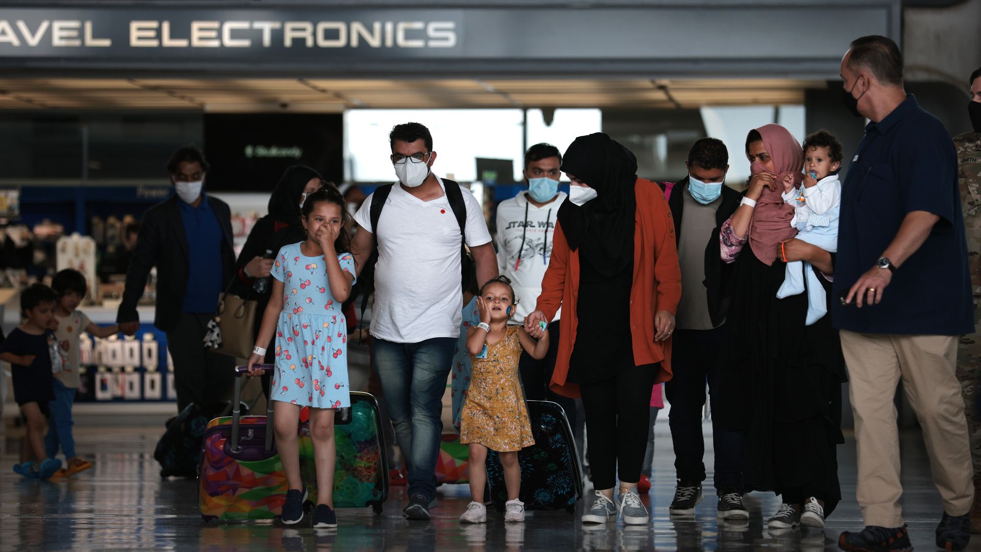 A photo of an Afghan family being led through an American airport