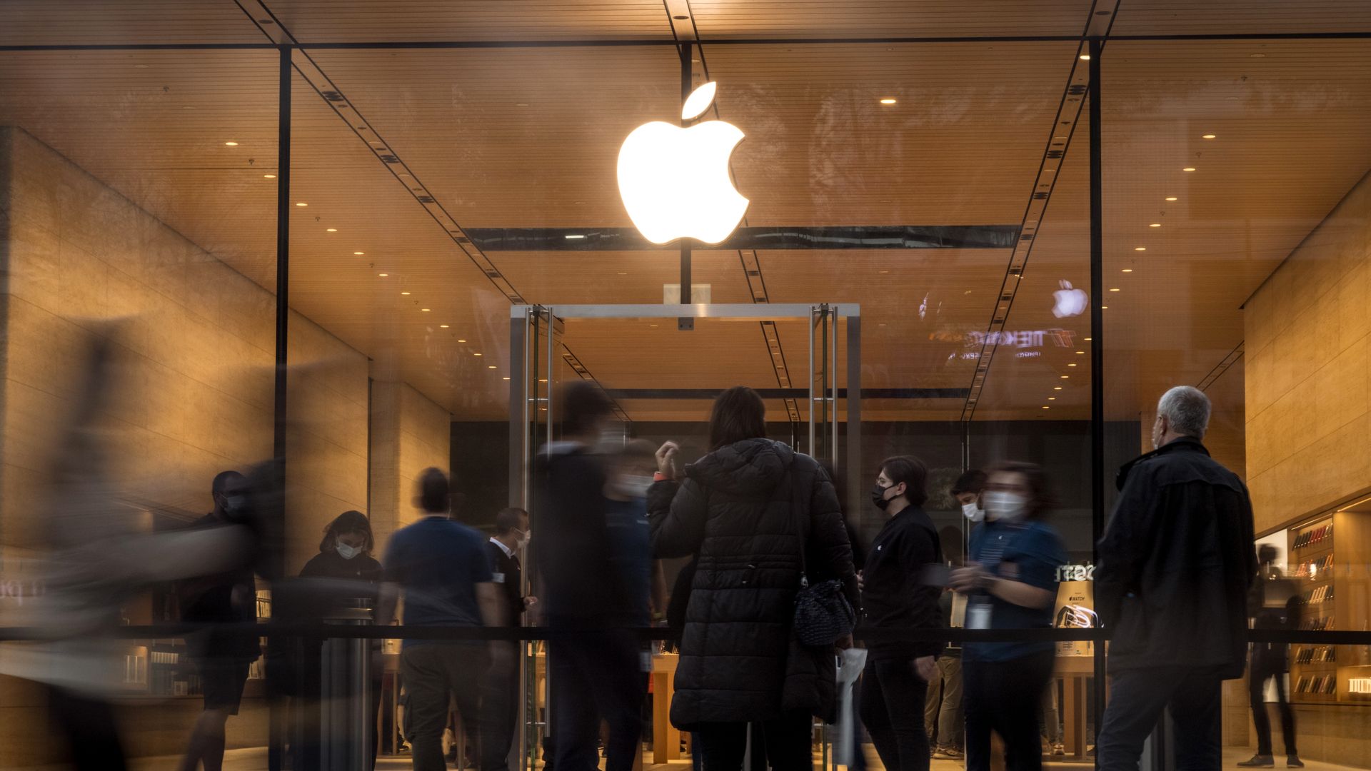 Image of people passing by an Apple store